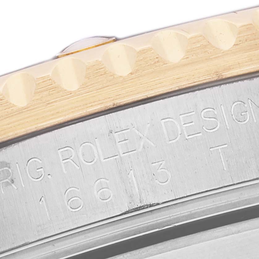 This image shows a close-up of the engraved side and portion of the bezel of a Rolex Submariner 16613 Men's Steel and Gold (two tone) Black Dial 16613 Men's Steel and Gold (two tone) Black Dial watch.