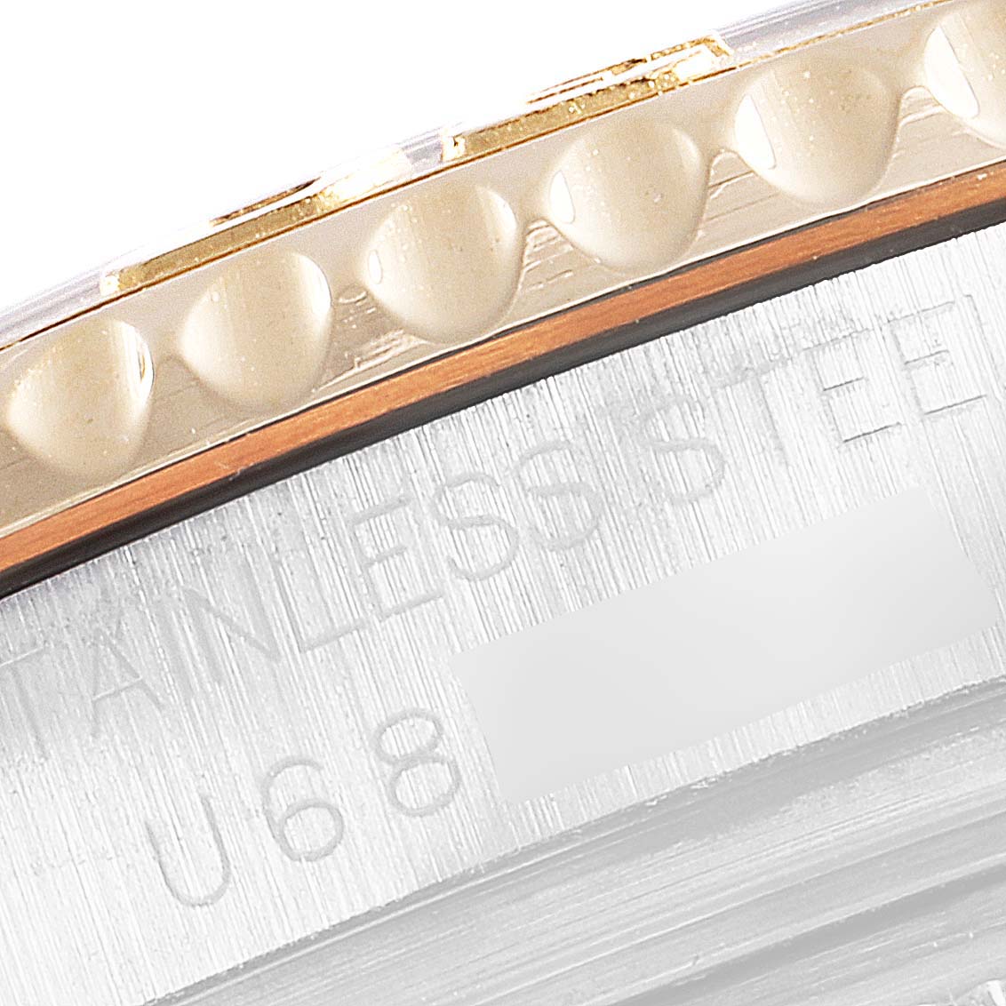 This close-up shows the bezel and part of the case of a Rolex Yacht-Master 68623 Men
s Steel and Gold (two tone) Champagne Dial 68623 Men
s Steel and Gold (two tone) Champagne Dial watch, highlighting the "stainless steel" engravings.