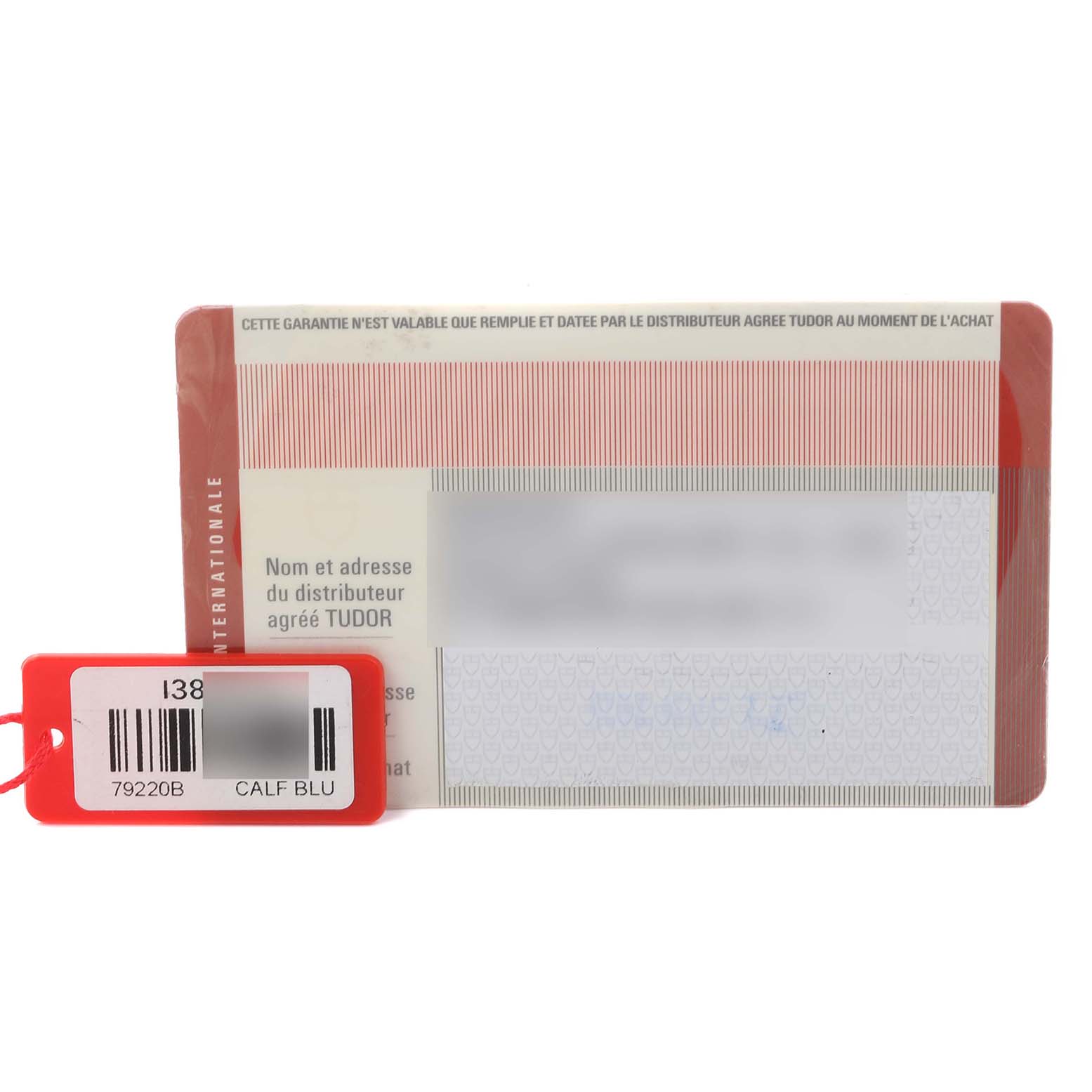 The image shows a guarantee card and a red tag for a Tudor Heritage Black Bay 79220B Men
s Stainless Steel Black Dial 79220B Men
s Stainless Steel Black Dial watch.