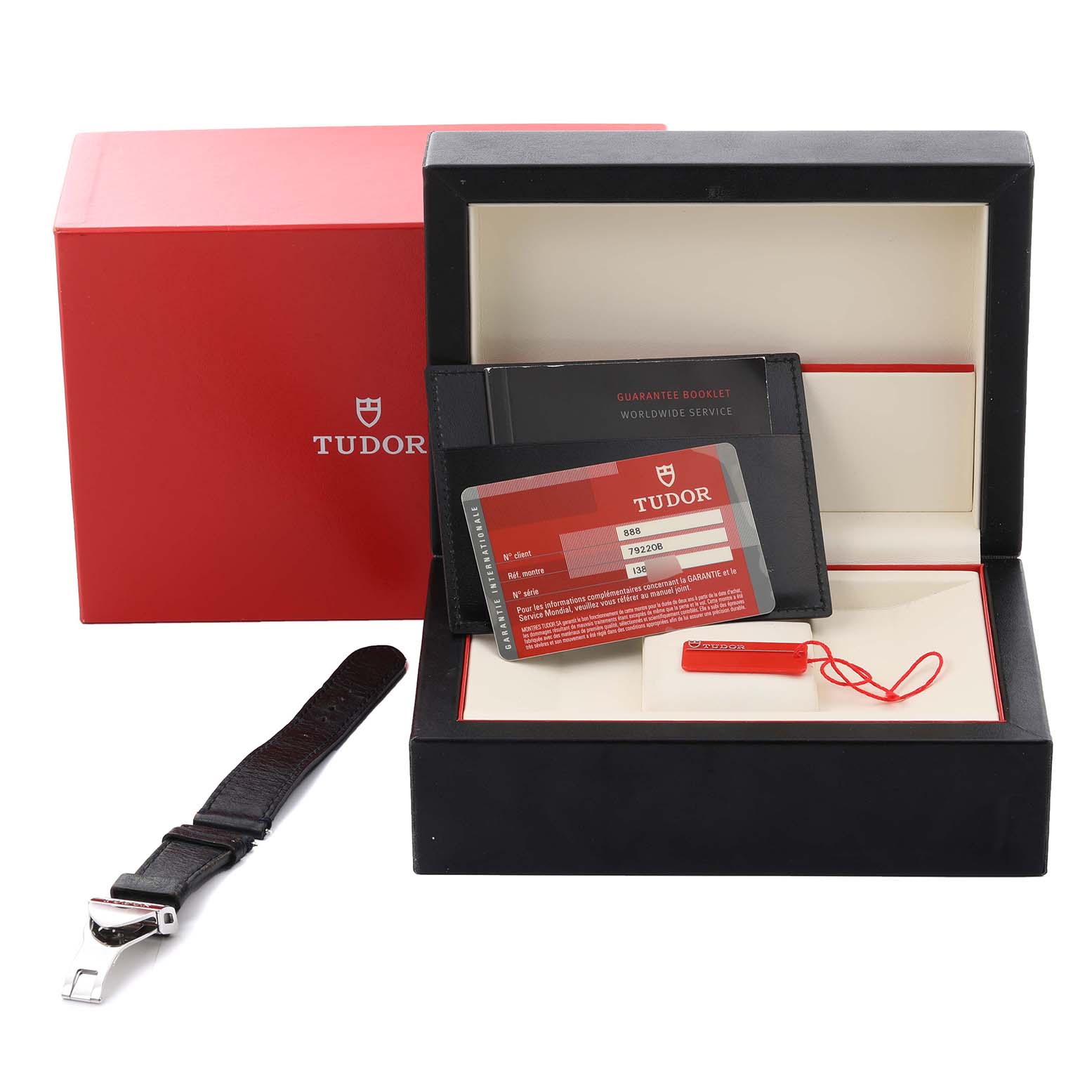 The image shows the packaging, warranty card, and extra strap for the Tudor Heritage Black Bay 79220B Men
s Stainless Steel Black Dial 79220B Men
s Stainless Steel Black Dial watch.