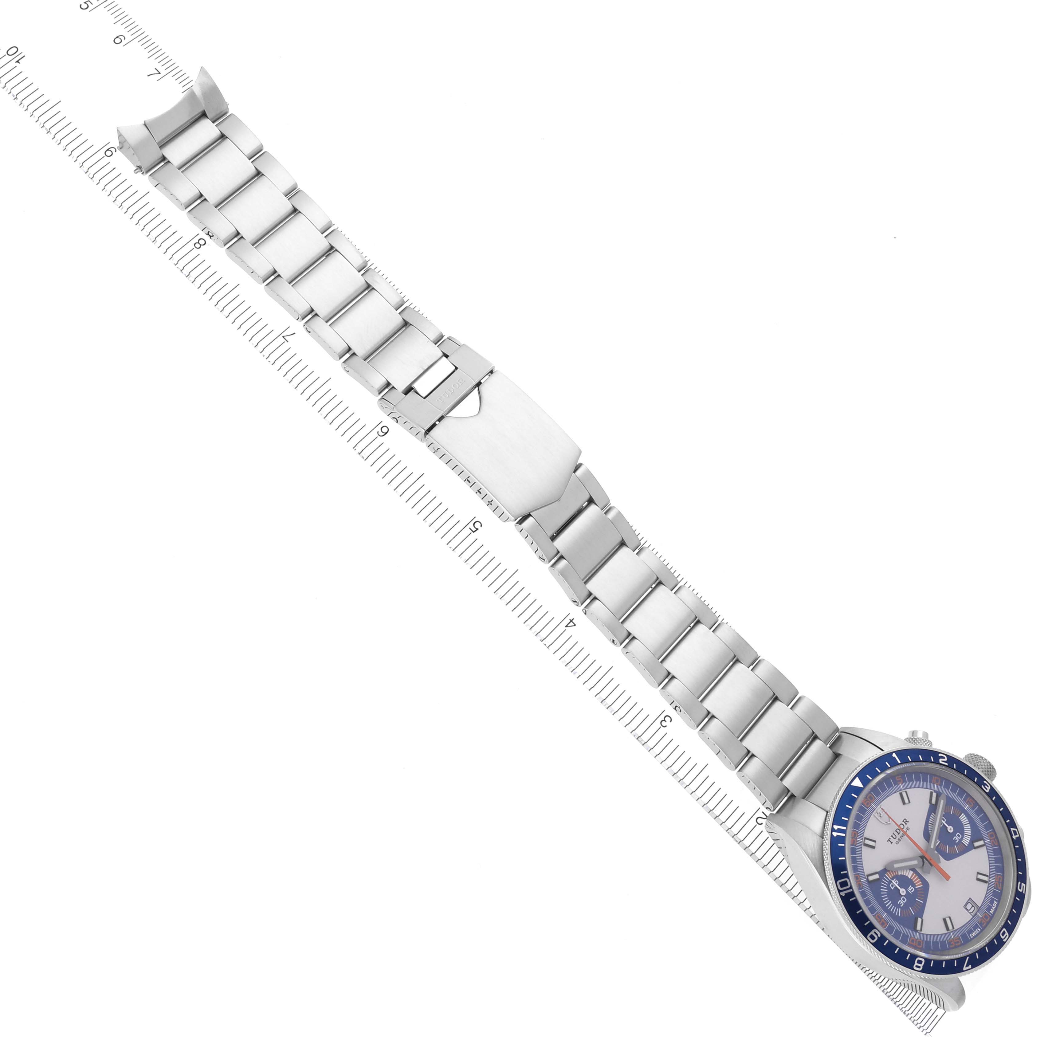The Tudor Heritage Chrono 70330 Men's Stainless Steel Blue Dial 70330 Men's Stainless Steel Blue Dial watch is shown from above, displaying the face, bezel, and full bracelet with an attached ruler.
