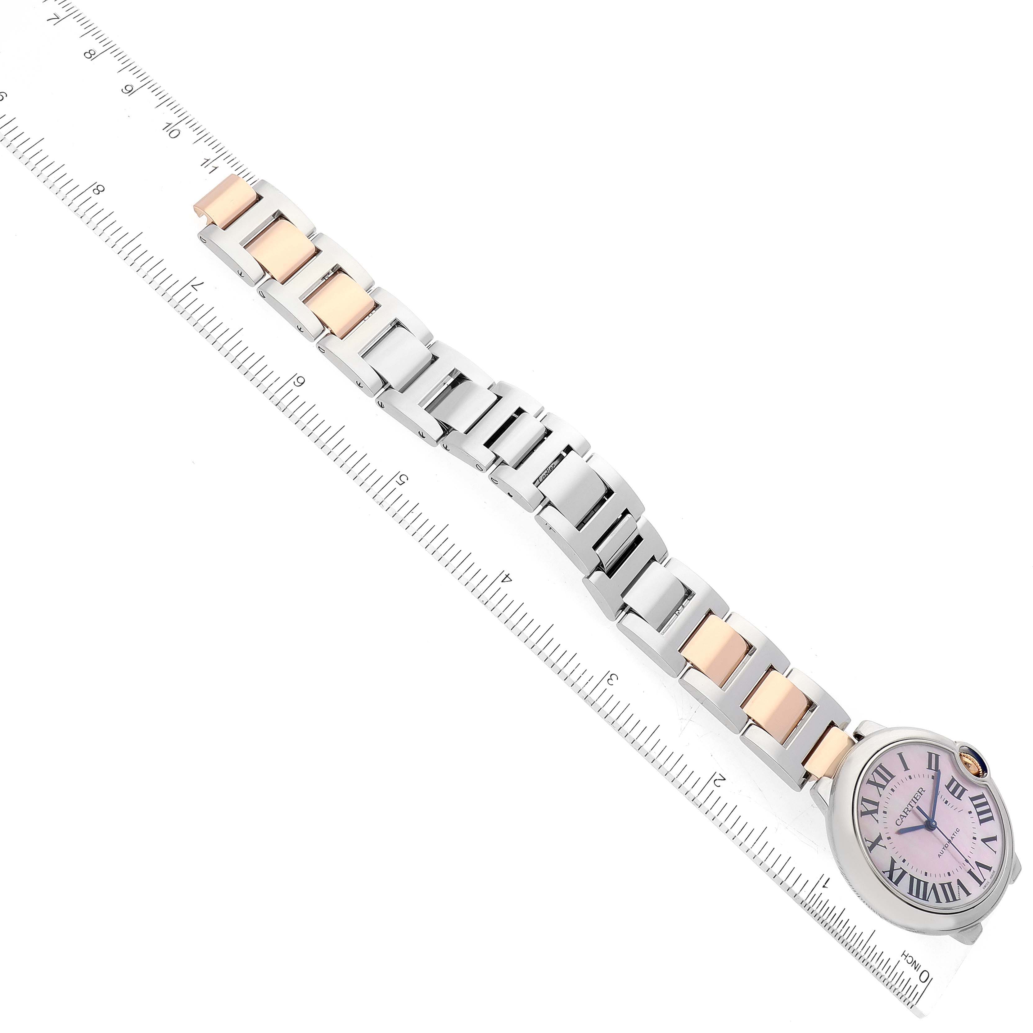 The image shows the bracelet and part of the dial of a Cartier Ballon Bleu W6920033 Women's Stainless Steel Mother of Pearl Dial W6920033 Women's Stainless Steel Mother of Pearl Dial watch at an angle with a ruler for scale.