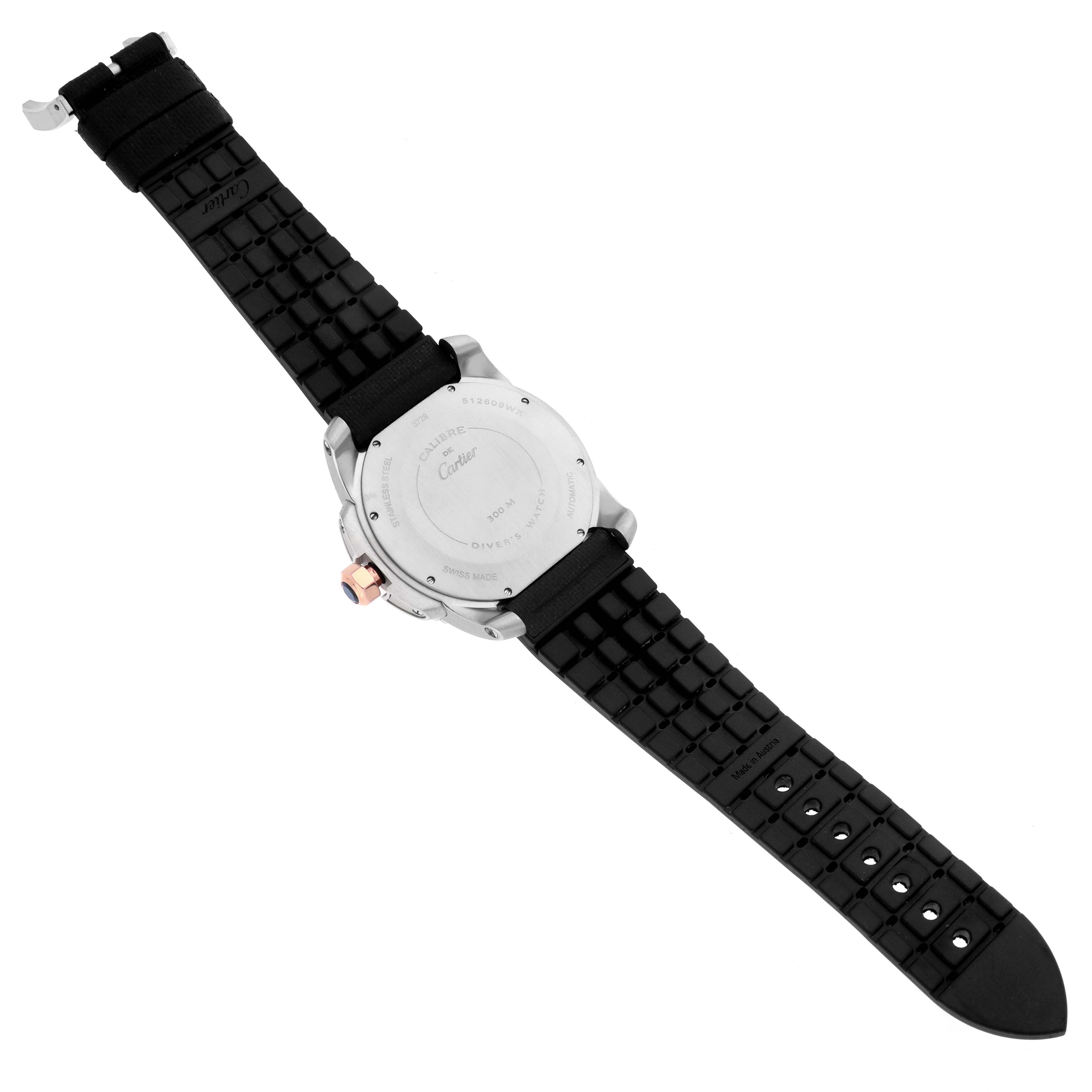 The Calibre de Cartier watch is shown from the back, displaying the stainless steel case back and black rubber strap.