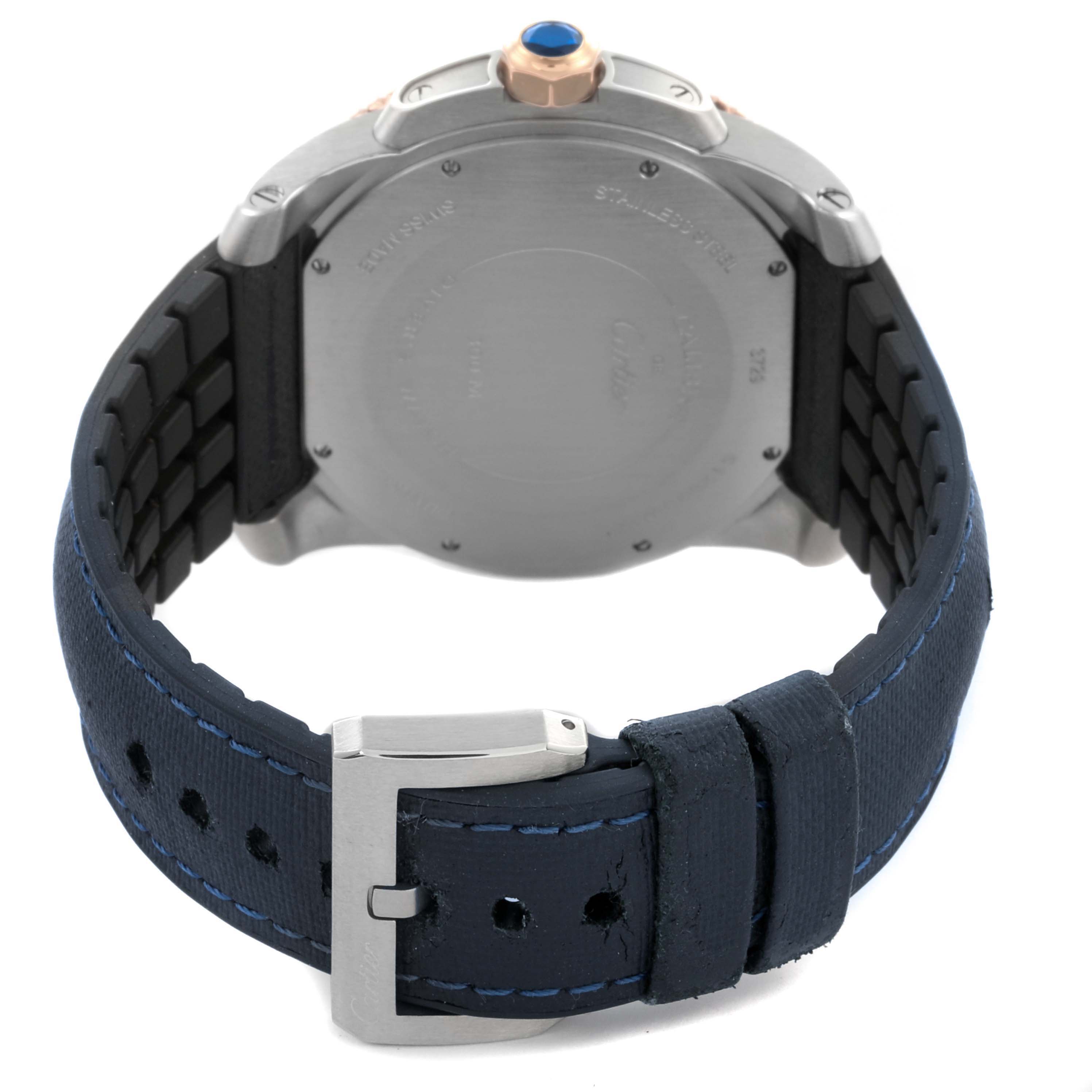 The Calibre de Cartier watch is shown from the back, highlighting the case, crown, and blue leather strap with a buckle.