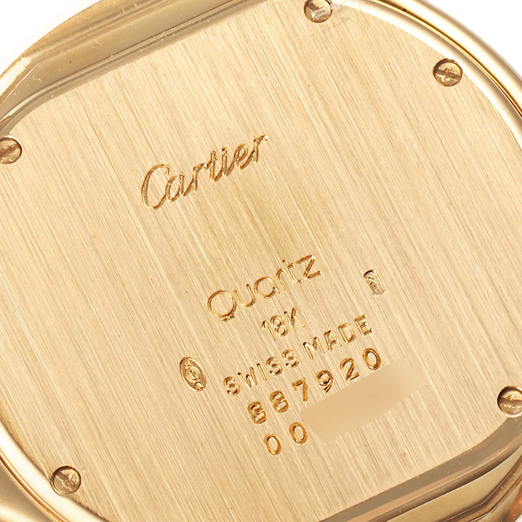 This image shows a close-up of the back case of a Cartier Panthere 887904 Women's Yellow Gold Silver Dial 887904 Women's Yellow Gold Silver Dial model watch, highlighting brand engravings and serial numbers.