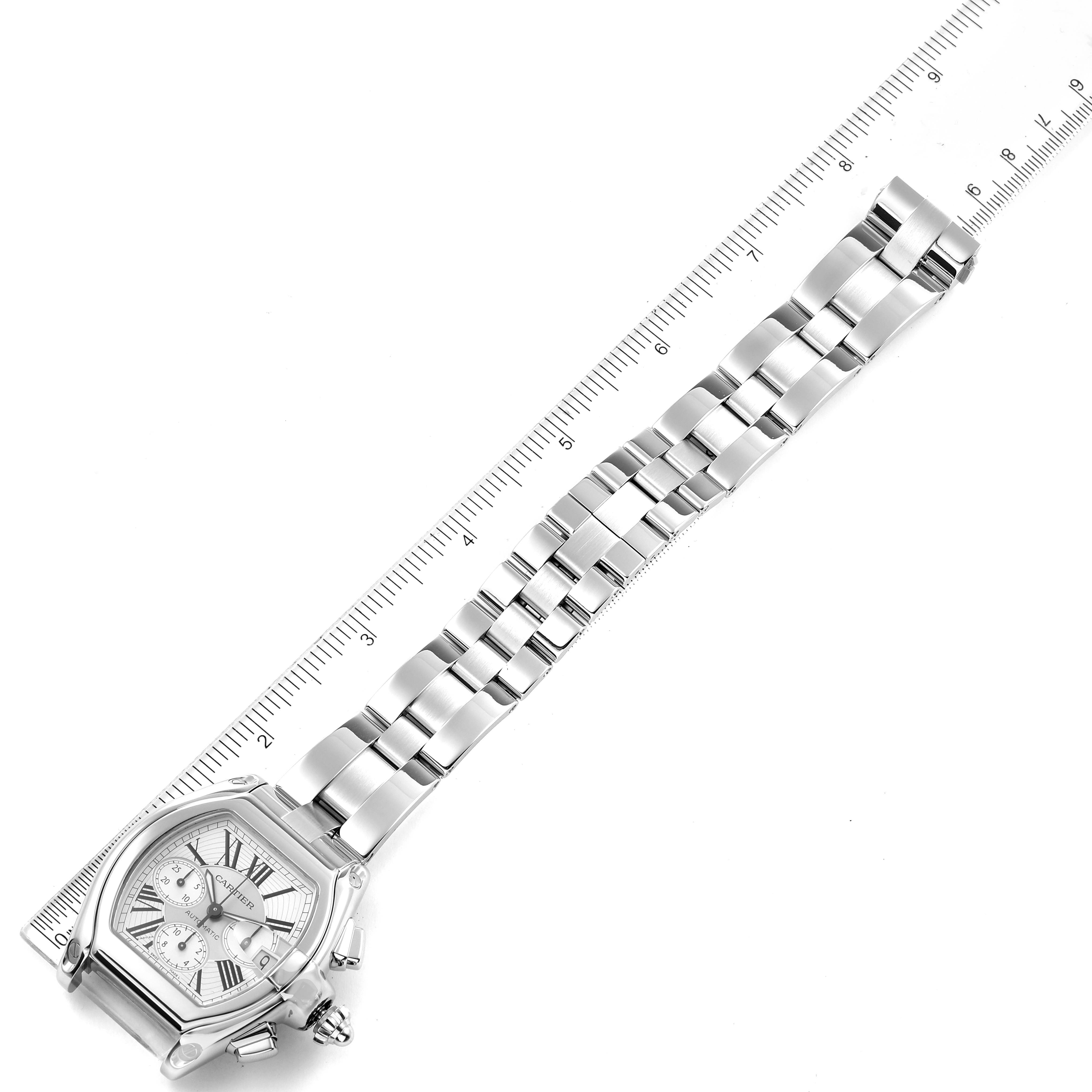 The Cartier Roadster W62019X6 Men
s Stainless Steel Silver Dial W62019X6 Men
s Stainless Steel Silver Dial watch is shown from an angled top view, prominently displaying the face, bracelet, and part of a ruler for scale.