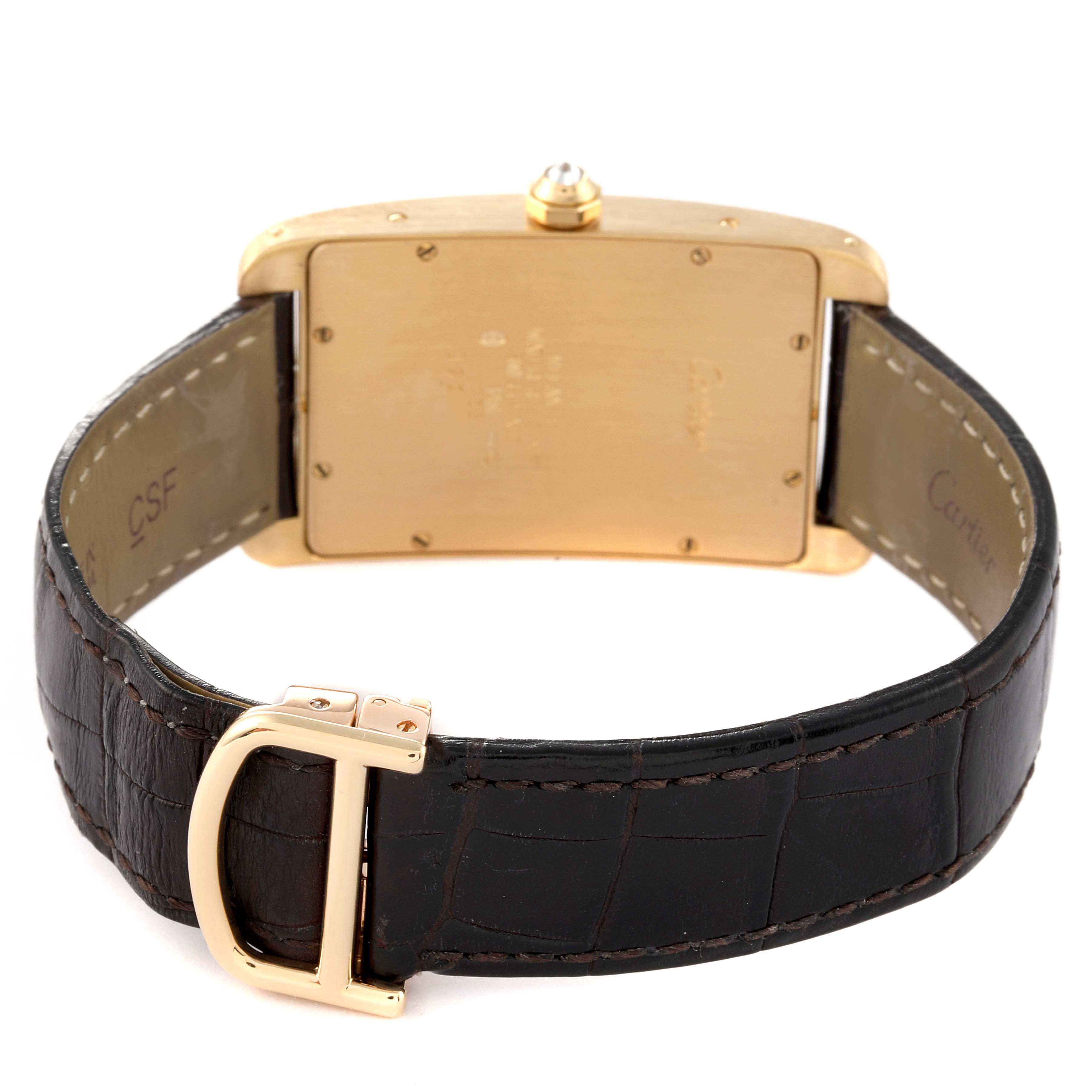 The image displays the back view of the Cartier Tank Americaine 1735 Men's Yellow Gold Silver Dial 1735 Men's Yellow Gold Silver Dial watch, focusing on its case back, leather strap, and buckle.