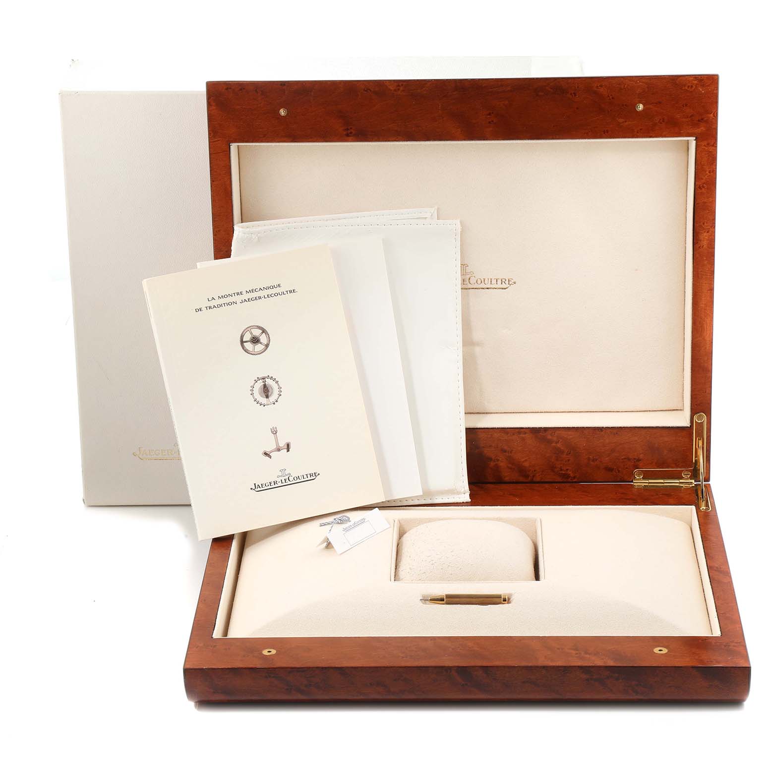 The image shows the open box of a Jaeger-LeCoultre Reverso model watch along with its documentation and packaging.