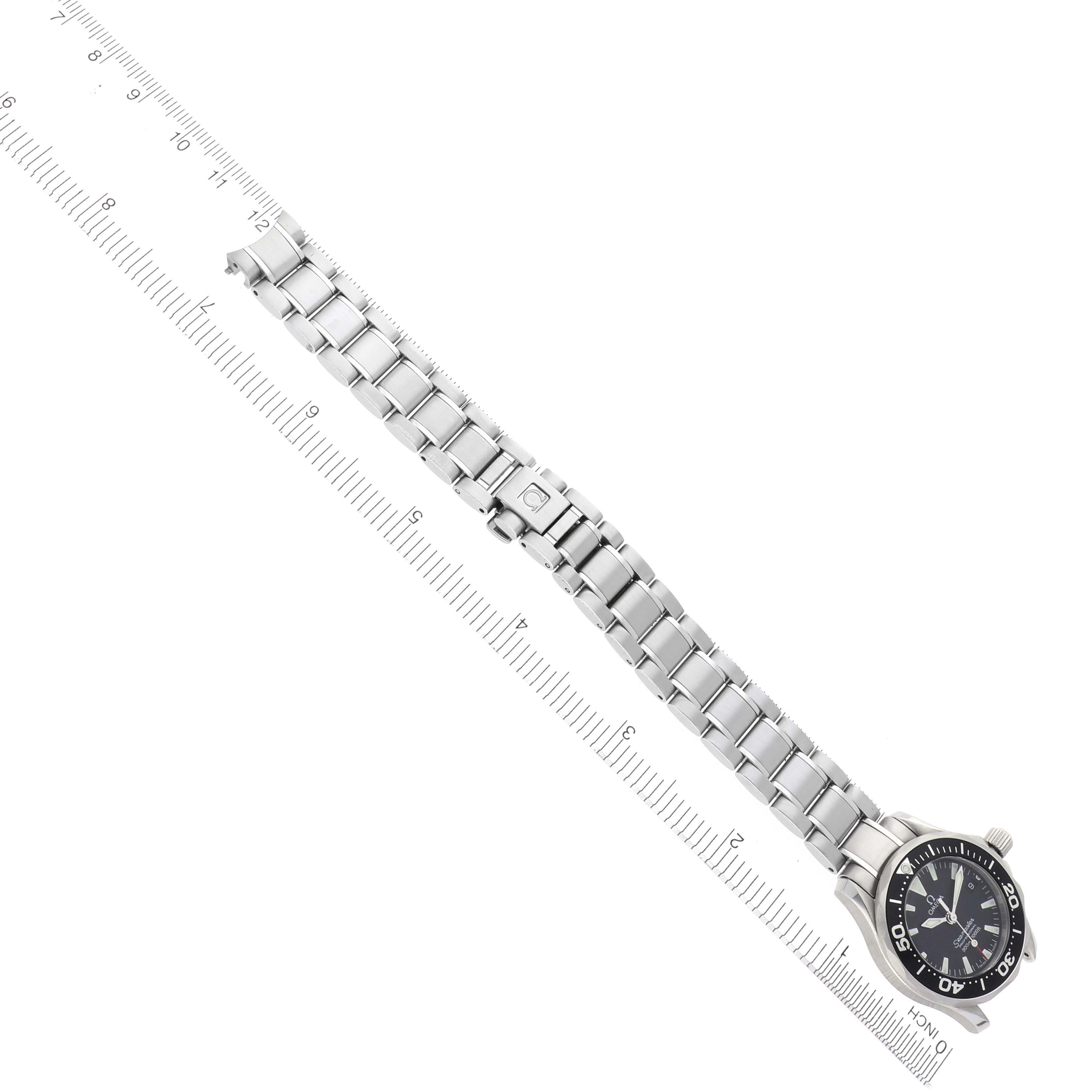 The Omega 2282.50.00 Women's Stainless Steel Black Dial 2282.50.00 Women's Stainless Steel Black Dial Seamaster Diver 300M Quartz 28mm is shown flat with its steel bracelet fully extended, alongside a ruler for scale.