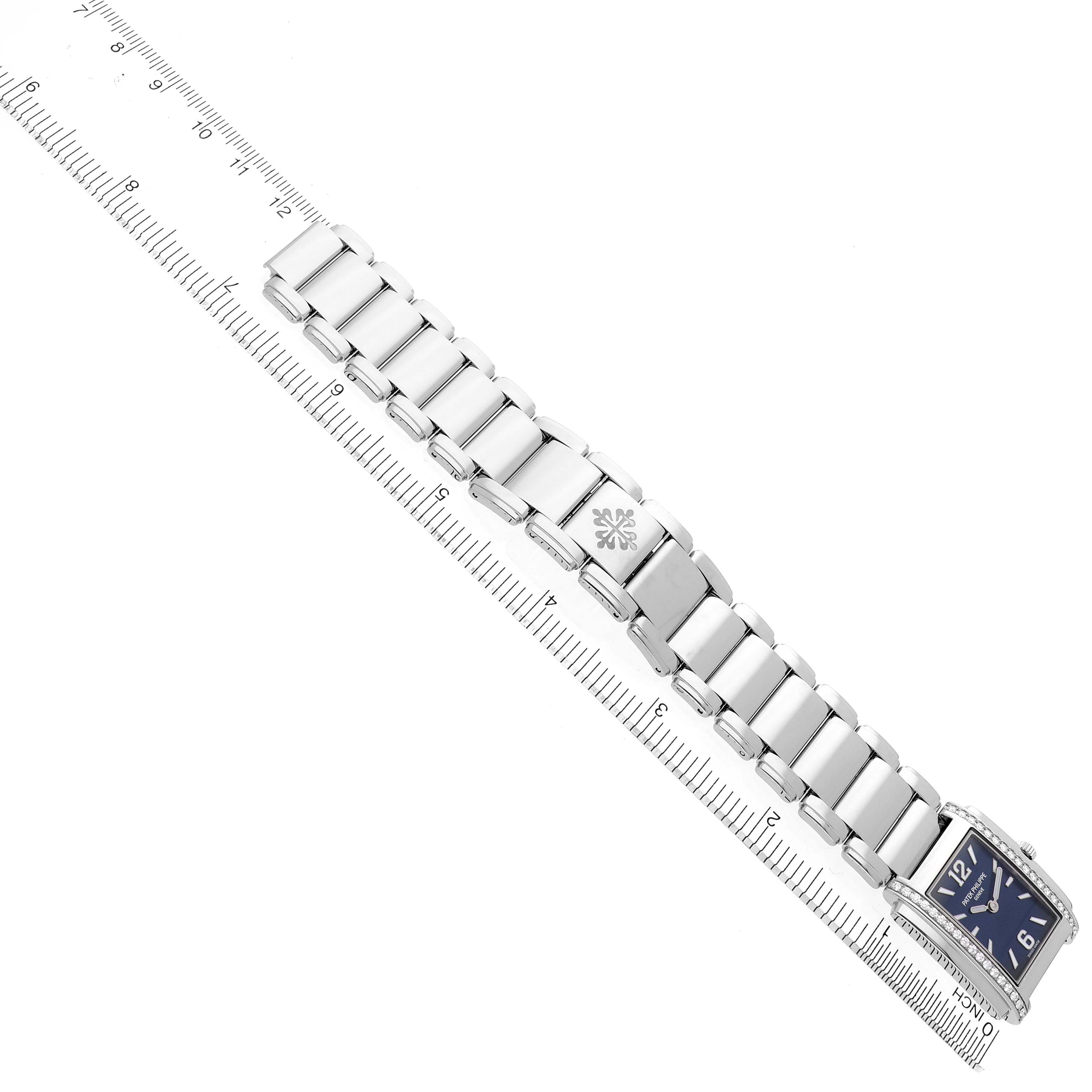 The image shows the Patek Philippe Twenty-4 4910/1200A-001 Women's Stainless Steel Blue Dial 4910/1200A-001 Women's Stainless Steel Blue Dial watch at an angled view, highlighting its bracelet and part of the face alongside a ruler.