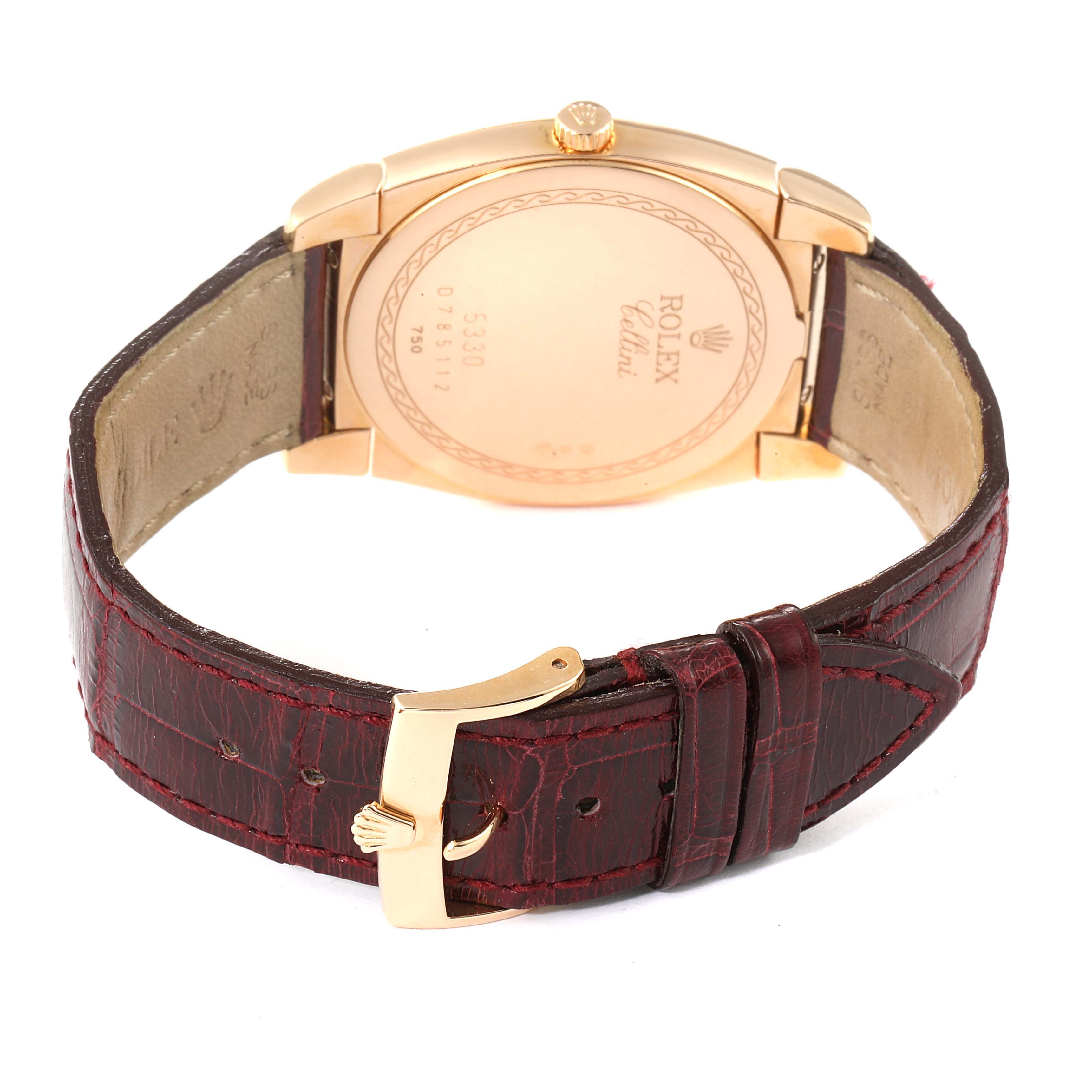 The image shows the back view of the Rolex Cellini 5330 Men's Rose Gold White Dial 5330 Men's Rose Gold White Dial watch, highlighting its gold case, engraved details, and leather strap with a gold buckle.