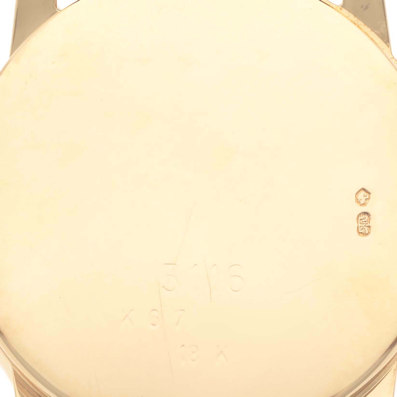 The image shows the back of a Rolex Cellini 5116 Men's Yellow Gold Champagne Dial 5116 Men's Yellow Gold Champagne Dial watch case with hallmark and engraving details.