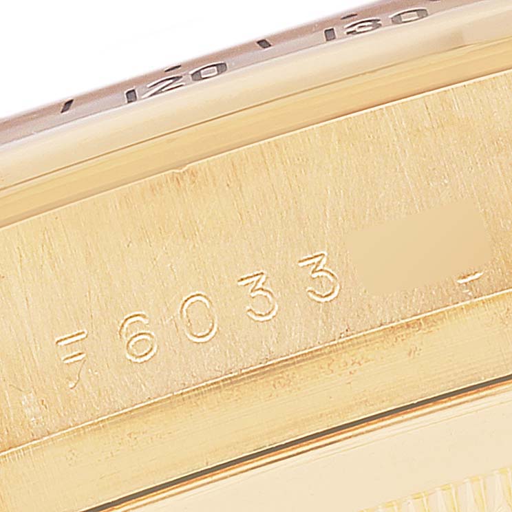 The image shows a close-up angle of the Rolex Daytona 116528 Men's Yellow Gold Black Dial 116528 Men's Yellow Gold Black Dial model's watch case with its serial number and part of its bezel.