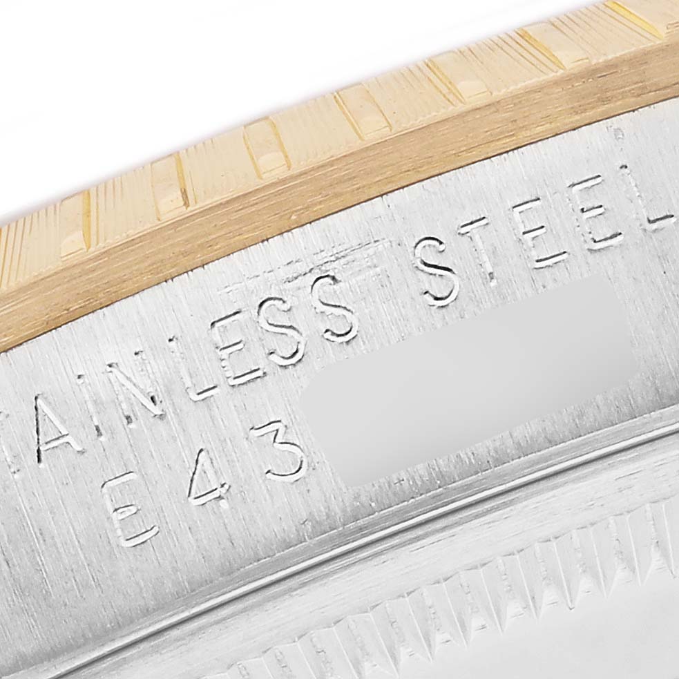 The image shows the edge and engravings on the rim of a Rolex Date 15223 Men's Steel and Gold (two tone) White Dial 15223 Men's Steel and Gold (two tone) White Dial model watch.