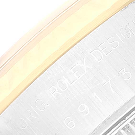 This image shows a close-up of the engraving on the case side of a Rolex Datejust 69173 Women's Steel and Gold (two tone) Champagne Dial 69173 Women's Steel and Gold (two tone) Champagne Dial model, highlighting text and part of the bezel.