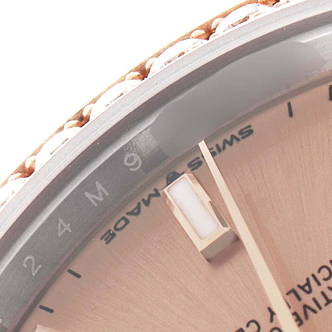 This close-up image of a Rolex Mid-Size 278381 Women's Steel and Gold (two tone) Pink Dial 278381 Women's Steel and Gold (two tone) Pink Dial model watch shows the edge of the dial, minute markings, bezel, and a portion of the hands.