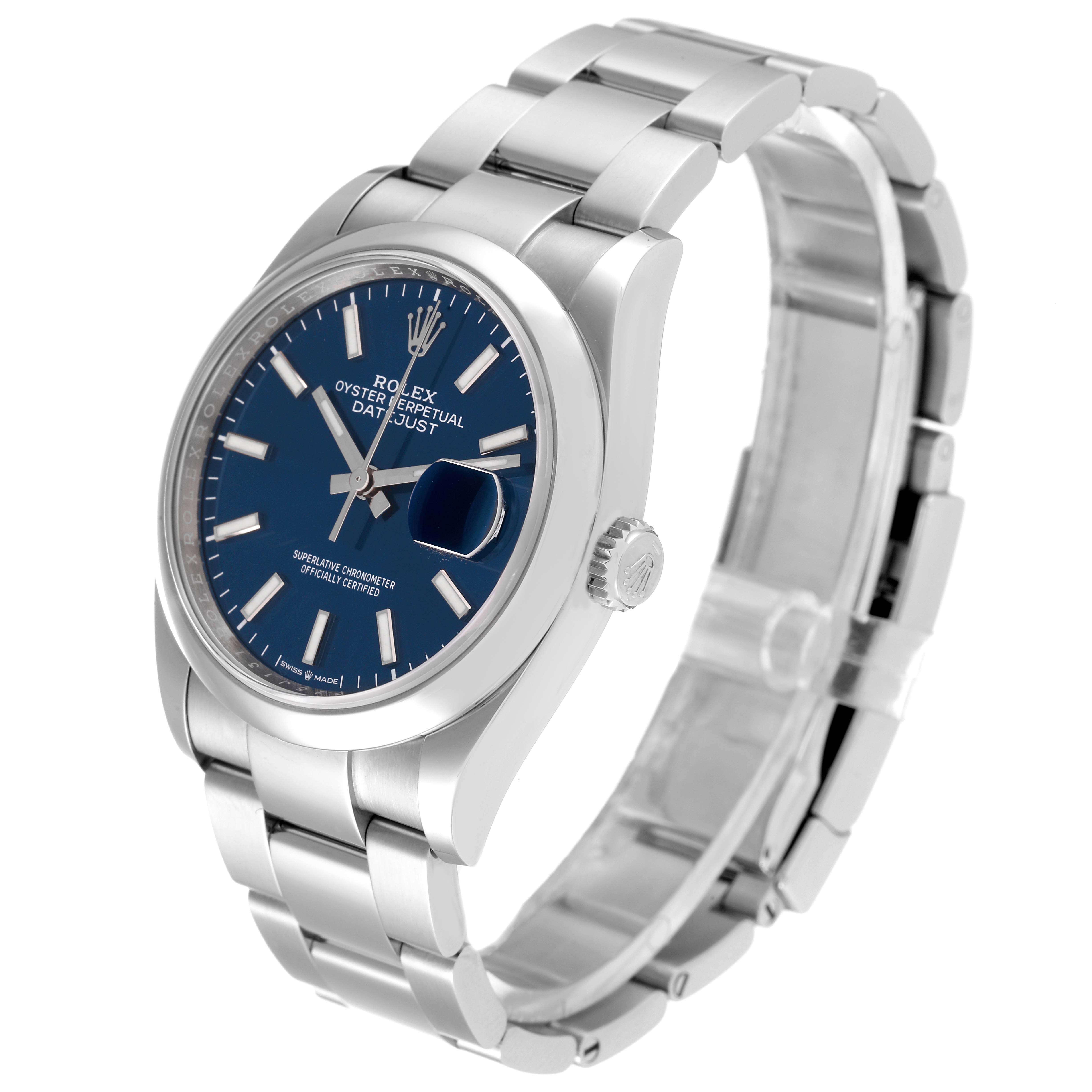 The Rolex Datejust 126200 Men's Stainless Steel Blue Dial 126200 Men's Stainless Steel Blue Dial watch is shown at a slight angle displaying its face, bezel, crown, and bracelet.