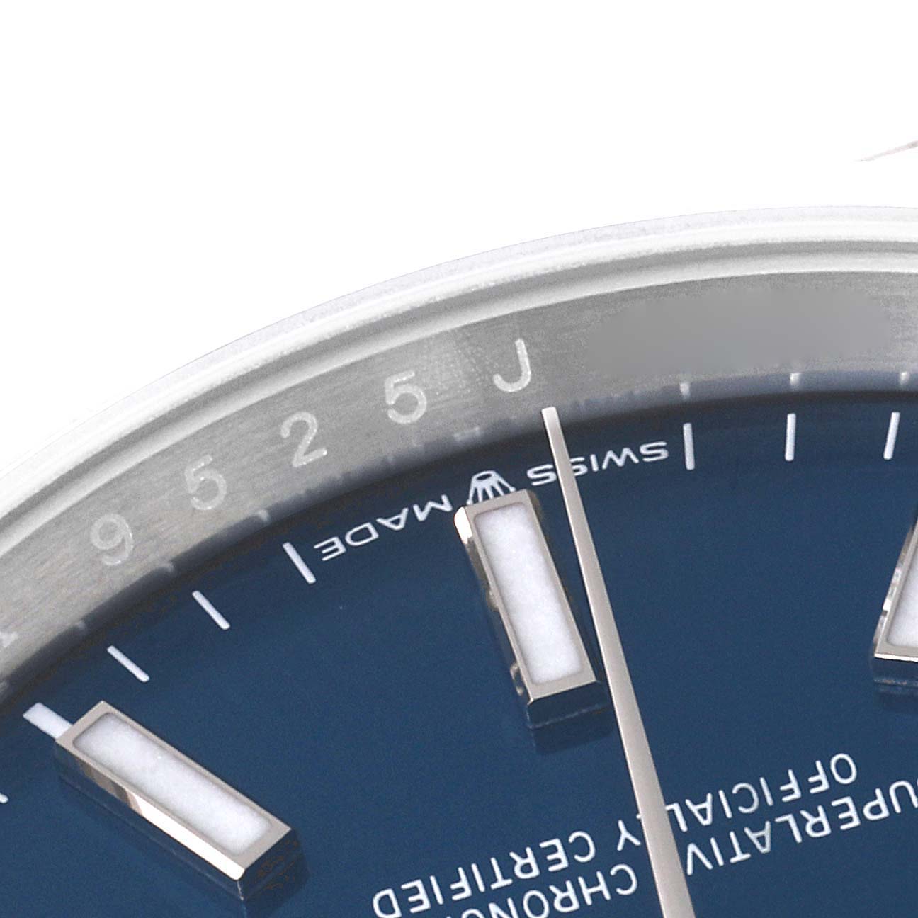 This close-up of a Rolex Datejust 126200 Men's Stainless Steel Blue Dial 126200 Men's Stainless Steel Blue Dial watch shows a portion of the bezel, dial, and markers.