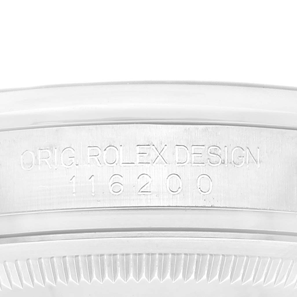 The image shows a close-up of the side of a Rolex Datejust 116200 Men's Stainless Steel Black Dial 116200 Men's Stainless Steel Black Dial model, highlighting the serial number and 'ORIG. ROLEX DESIGN' engraving.