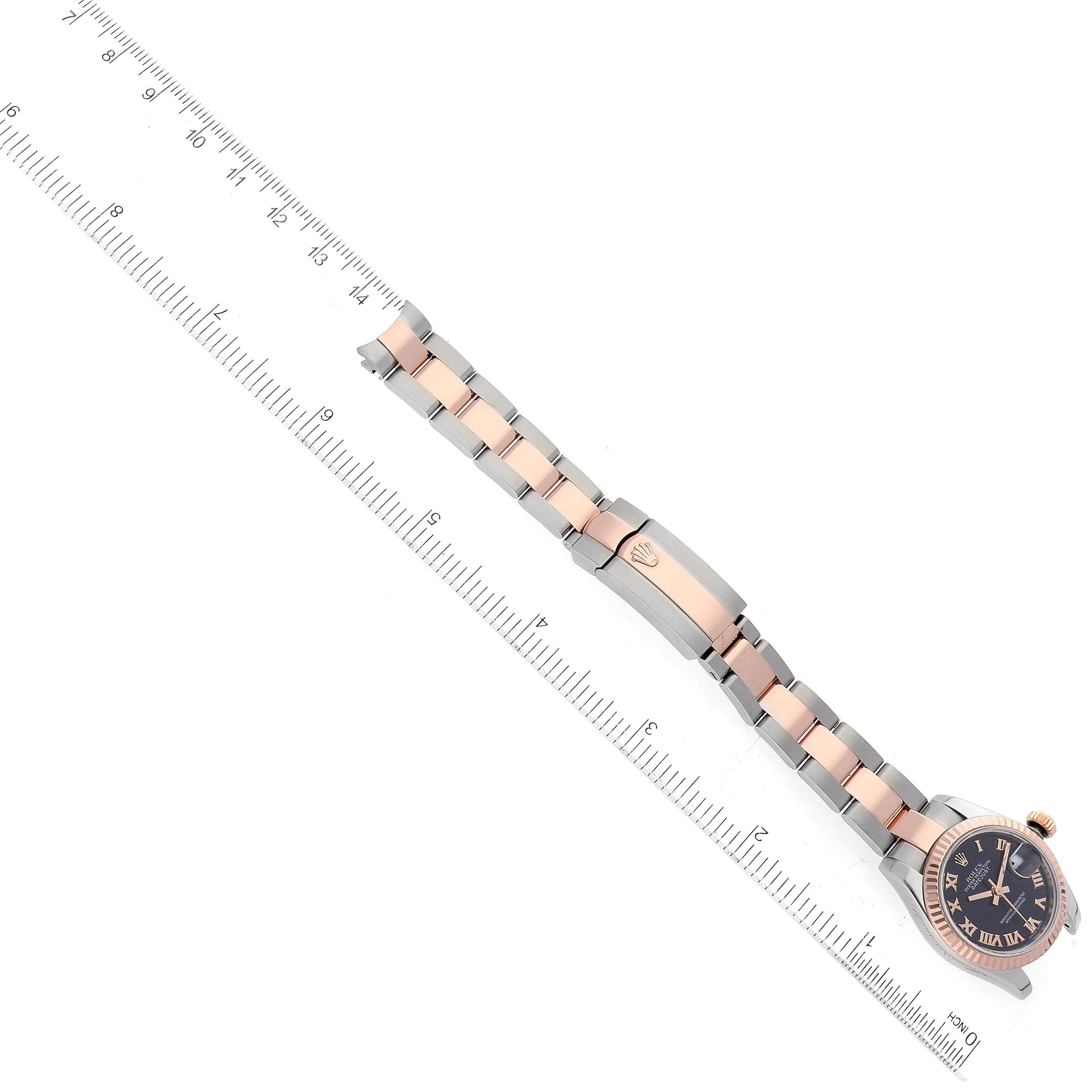 The image shows a top-down view of a Rolex Datejust 179171 Women's Steel and Gold (two tone) Black Dial 179171 Women's Steel and Gold (two tone) Black Dial watch with a ruler for scale.