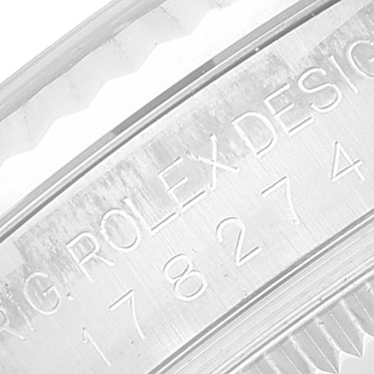 The image shows a close-up of the engraved serial number and design details on the side of a Mid-Size Rolex watch case.