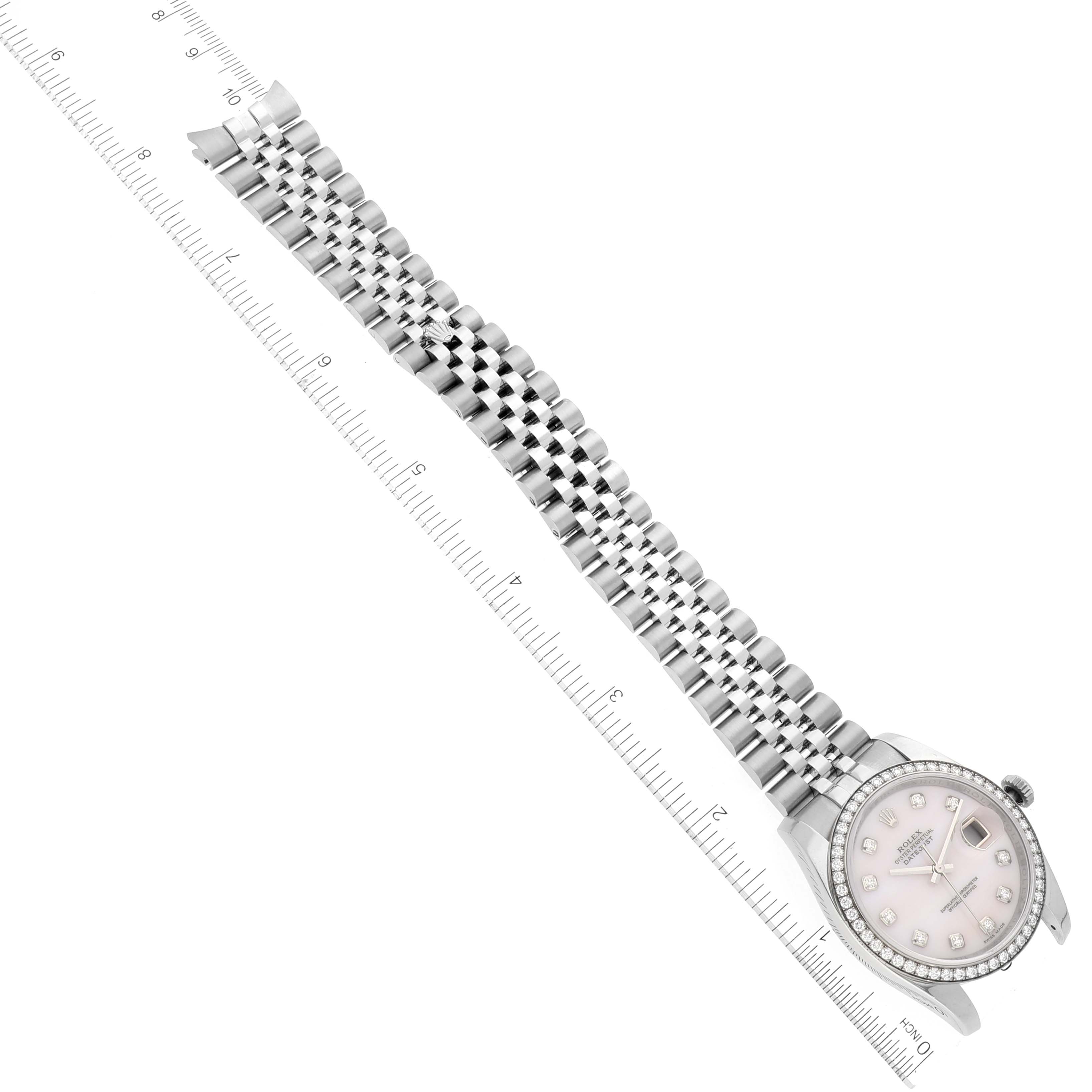 The image shows a top-down view of a Rolex Datejust 116244 Men's Stainless Steel Mother of Pearl Dial 116244 Men's Stainless Steel Mother of Pearl Dial watch, highlighting its face, bezel, and bracelet alongside a measuring ruler.