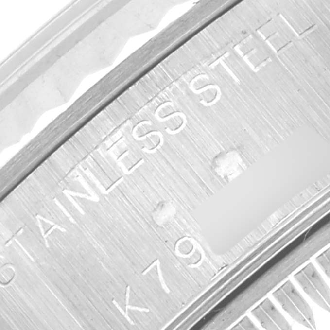 The image shows a close-up of the backside engraving on a Rolex Datejust 79174 Women's Stainless Steel Mother of Pearl Dial 79174 Women's Stainless Steel Mother of Pearl Dial, highlighting "STAINLESS STEEL" and a partial serial number.