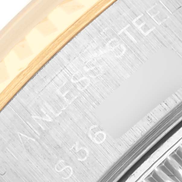 The image shows a close-up of the side of a Rolex Datejust 69173G Women's Steel and Gold (two tone) Champagne Dial 69173G Women's Steel and Gold (two tone) Champagne Dial, focusing on the stainless steel and gold edge with engraved text.