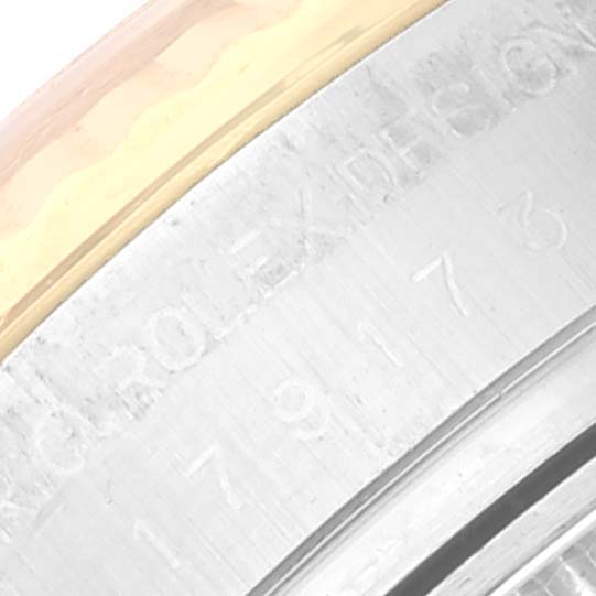 This is a close-up view of the side of the bezel and case of a Rolex Datejust 179173 Women's Steel and Gold (two tone) Champagne Dial 179173 Women's Steel and Gold (two tone) Champagne Dial watch, showing engraved details.