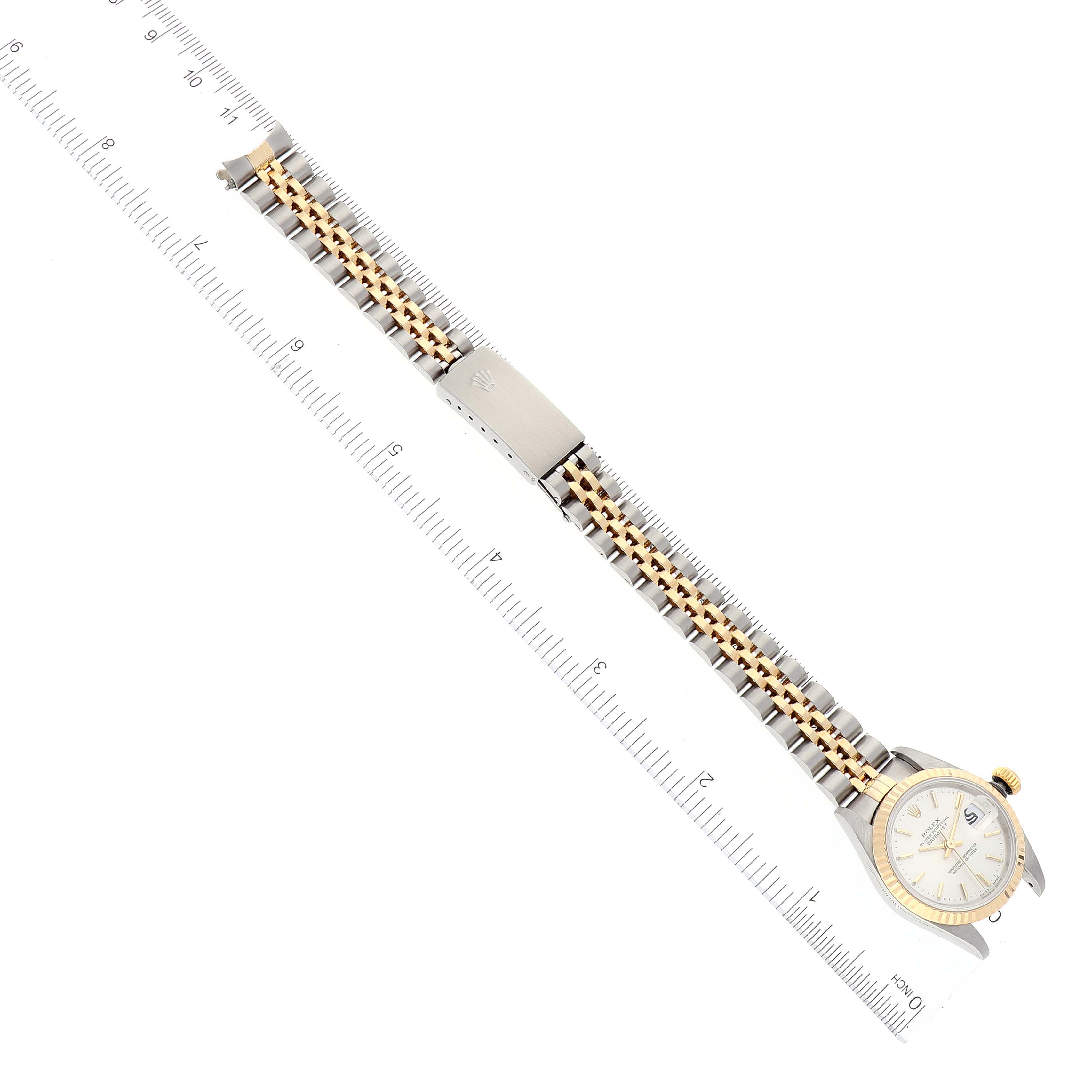 The image shows a Rolex Datejust 79173 Women's Steel and Gold (two tone) Silver Dial 79173 Women's Steel and Gold (two tone) Silver Dial watch laid flat next to a ruler, displaying its face, bezel, and bracelet from a top-down angle.