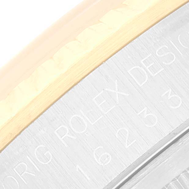 This close-up image of the Rolex Datejust 16233 Men's Steel and Gold (two tone) White Dial 16233 Men's Steel and Gold (two tone) White Dial watch shows part of the bezel and the engraved side of the case.