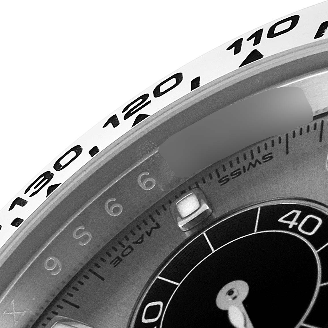 This close-up image of a Rolex Daytona 116509 Men's White Gold Silver Dial 116509 Men's White Gold Silver Dial watch shows part of the bezel with the tachymeter scale and part of the watch face.
