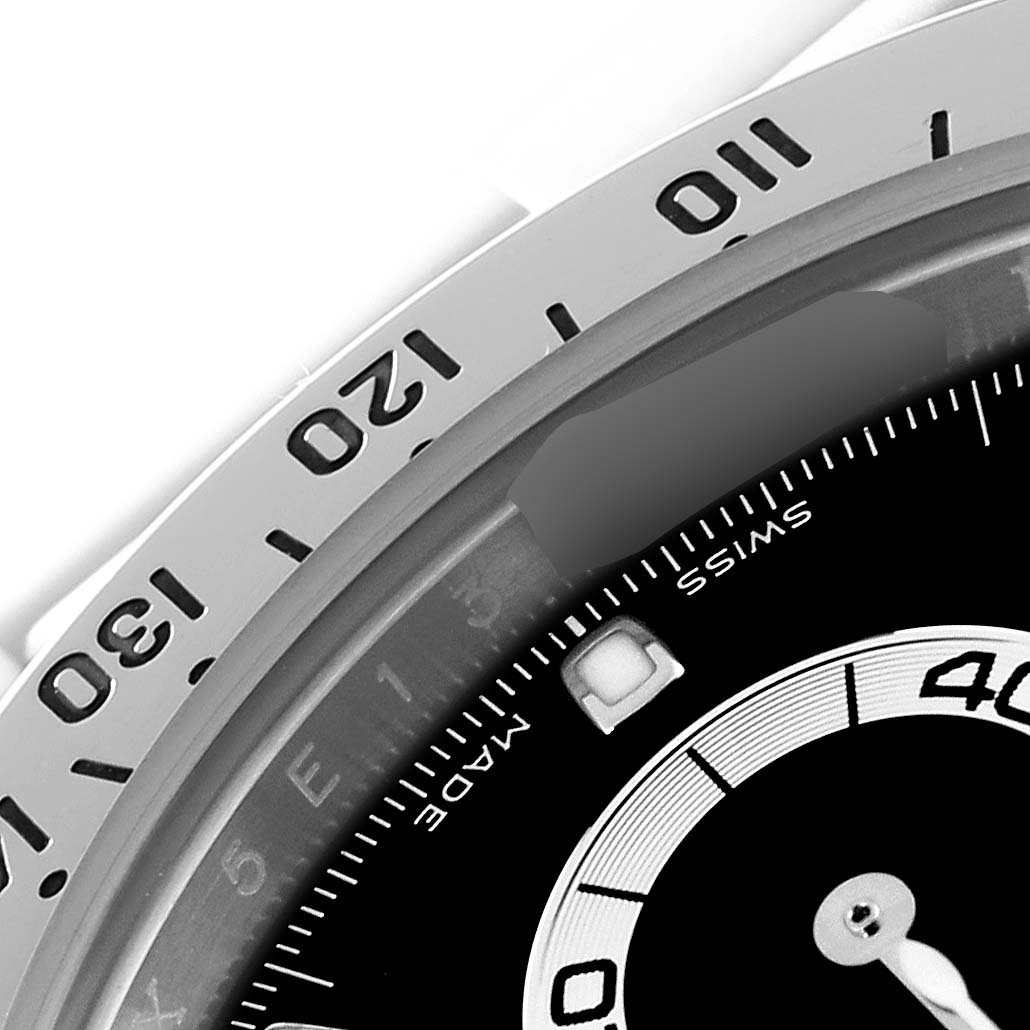 The image shows a close-up of the bezel and part of the dial of a Rolex Daytona 116520 Men's Stainless Steel Black Dial 116520 Men's Stainless Steel Black Dial watch.