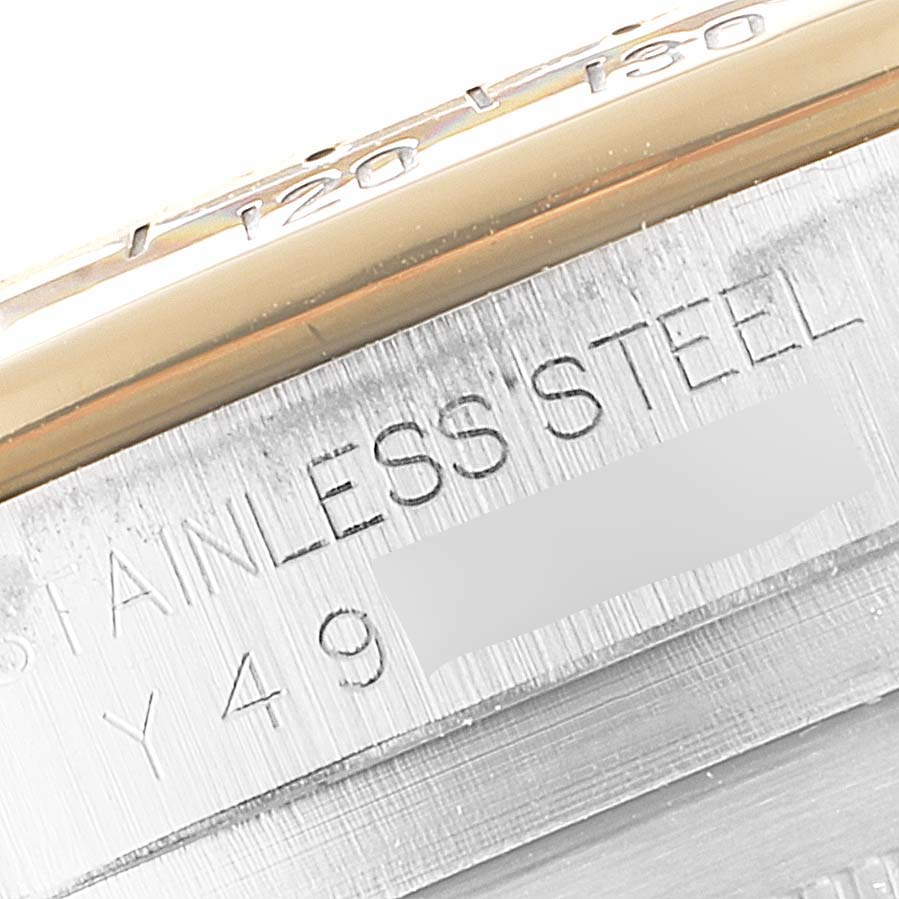 This close-up image shows the engraved stainless steel part and partial bezel of a Rolex Daytona 116523 Men
s Steel and Gold (two tone) Black Dial 116523 Men
s Steel and Gold (two tone) Black Dial watch.