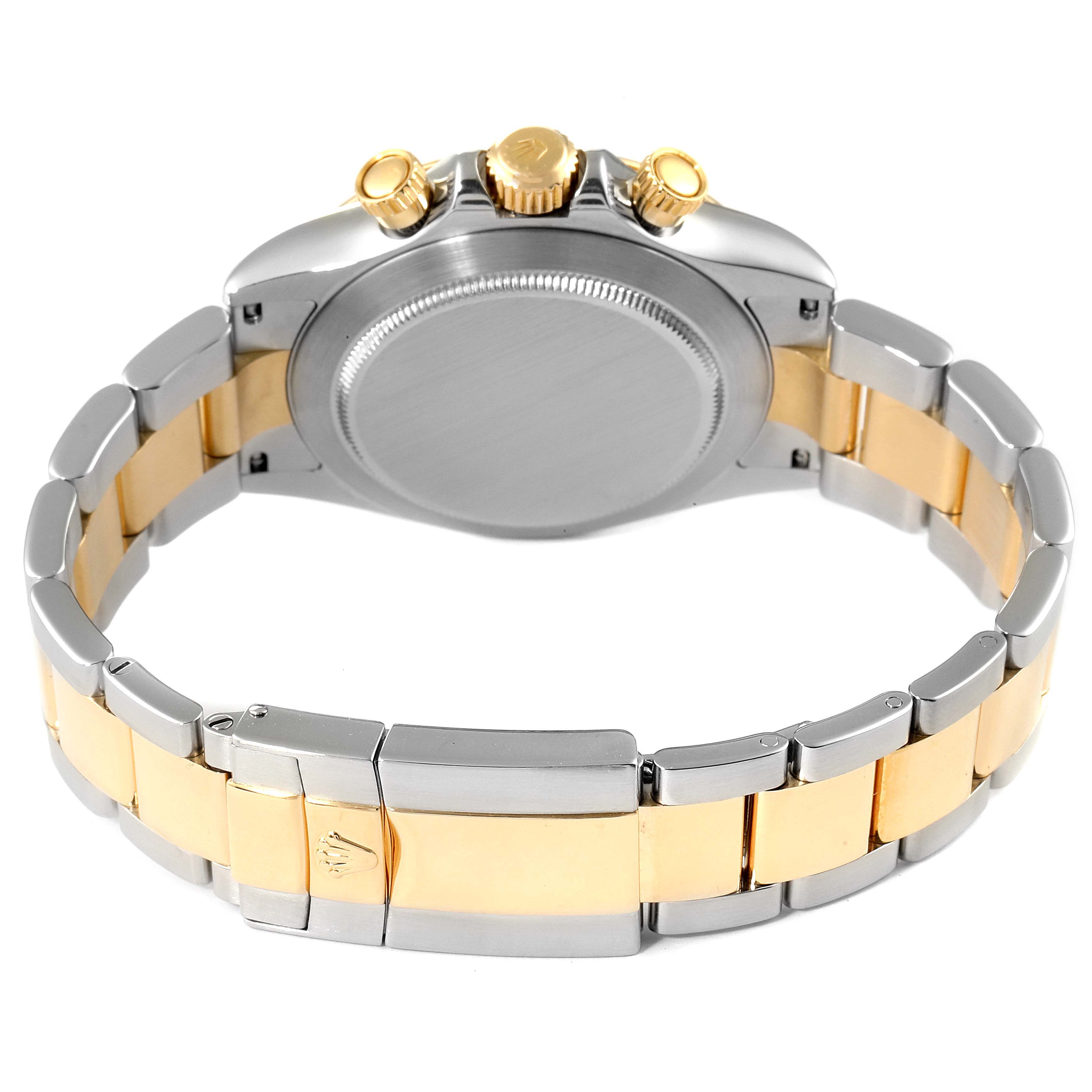 This image shows the back view of a Rolex Daytona 116523 Men
s Steel and Gold (two tone) Black Dial 116523 Men
s Steel and Gold (two tone) Black Dial watch, highlighting its case back, crown, pushers, and two-tone bracelet.