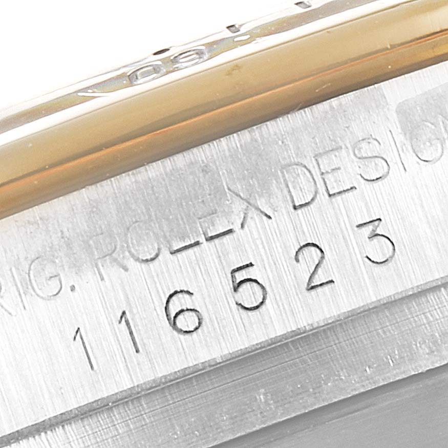 The image shows a close-up of the Rolex Daytona 116523 Men
s Steel and Gold (two tone) Black Dial 116523 Men
s Steel and Gold (two tone) Black Dial model
s case side, revealing model number 116523 engraved.