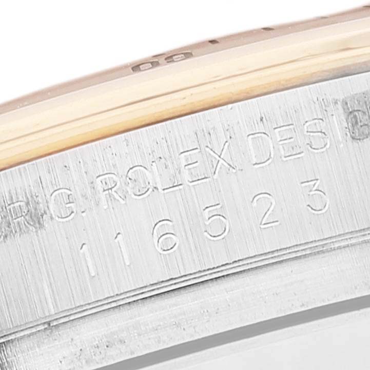 This close-up image shows the engraved model number and bezel edge of a Rolex Daytona 116523 Men's Steel and Gold (two tone) Mother of Pearl Dial 116523 Men's Steel and Gold (two tone) Mother of Pearl Dial watch.