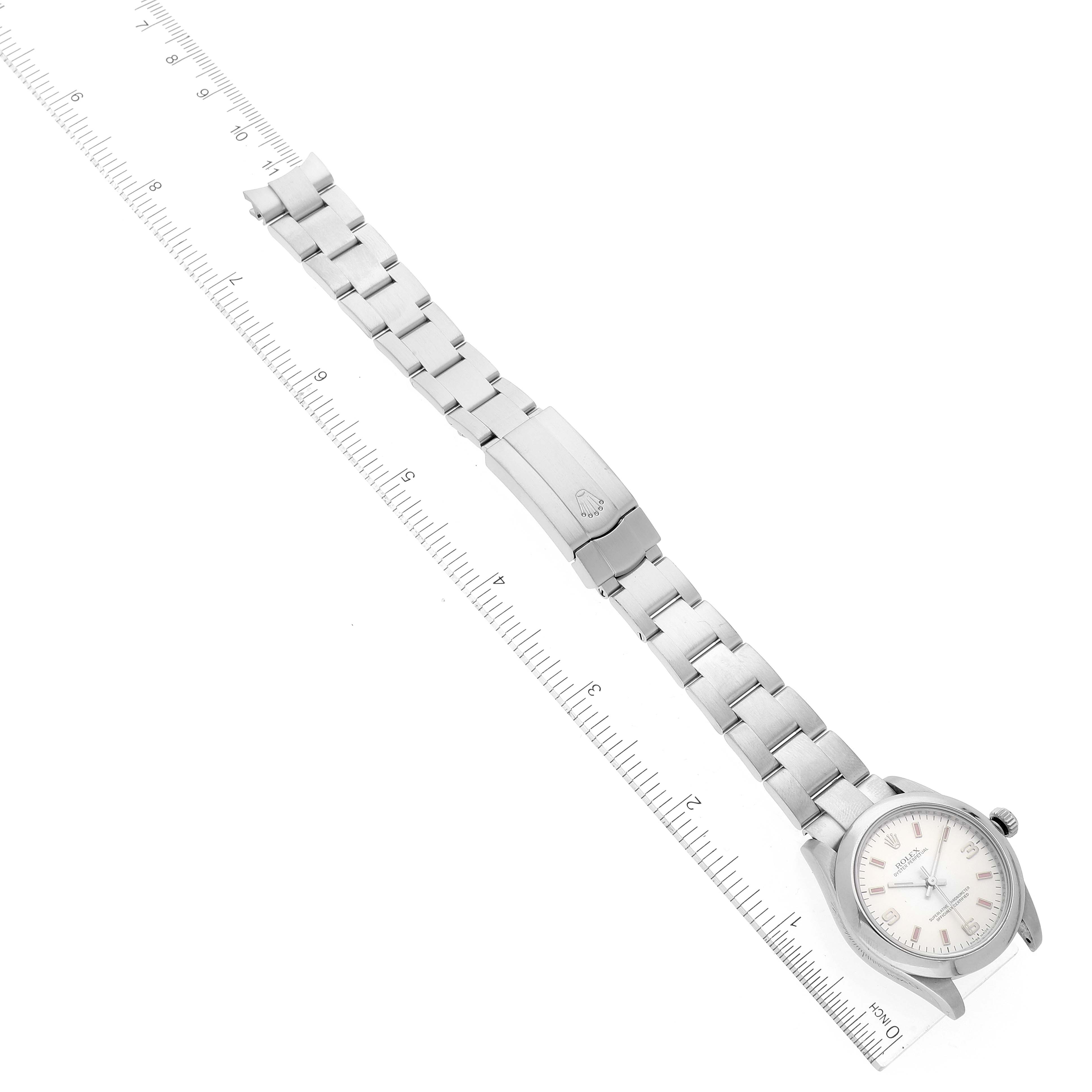 The Rolex Mid-Size 177200 Women
s Stainless Steel Silver Dial 177200 Women
s Stainless Steel Silver Dial watch is shown flat with the bracelet and clasp opened, positioned next to a ruler for scale.