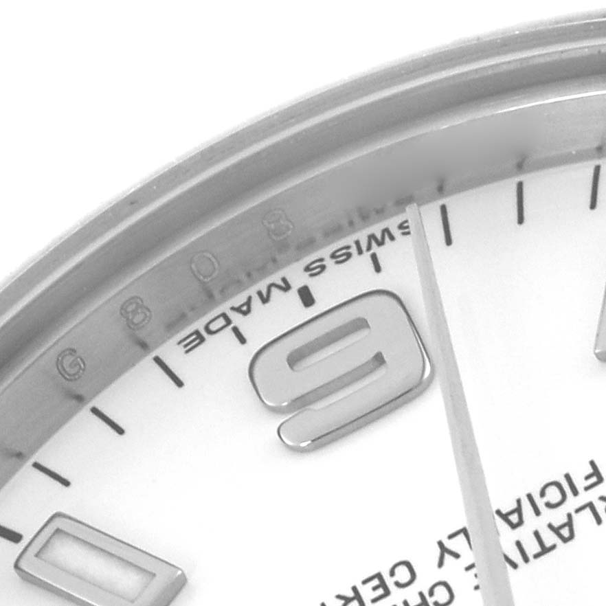 The image shows a close-up of a Rolex Mid-Size 177200 Women's Stainless Steel White Dial 177200 Women's Stainless Steel White Dial watch face, focusing on the bezel, part of the dial, and a number.