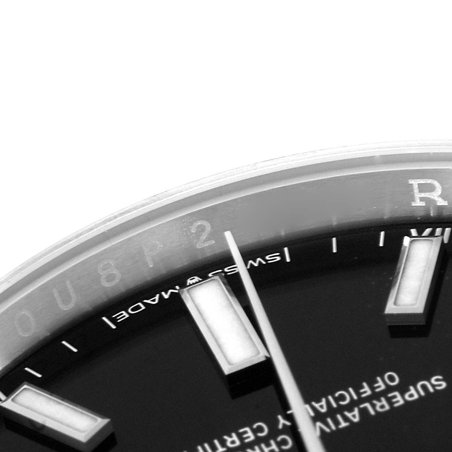 The image shows a close-up of the top-right portion of the dial of a Rolex Oyster Perpetual 124200 Men's Stainless Steel Black Dial 124200 Men's Stainless Steel Black Dial watch, displaying the hour markers and part of the text.
