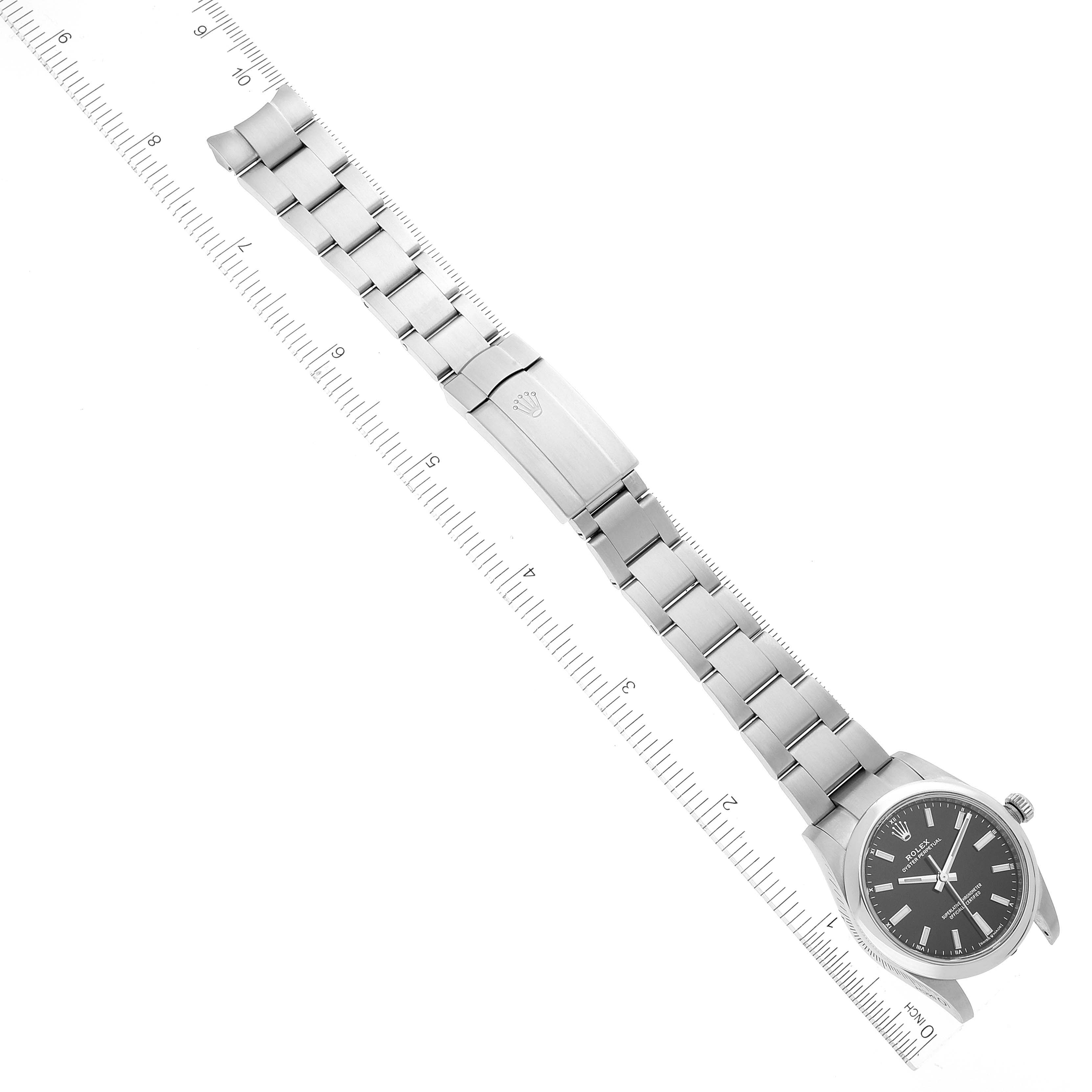 This image shows a Rolex Oyster Perpetual 124200 Men's Stainless Steel Black Dial 124200 Men's Stainless Steel Black Dial watch laid flat with its bracelet extended and positioned alongside a ruler for measurement.