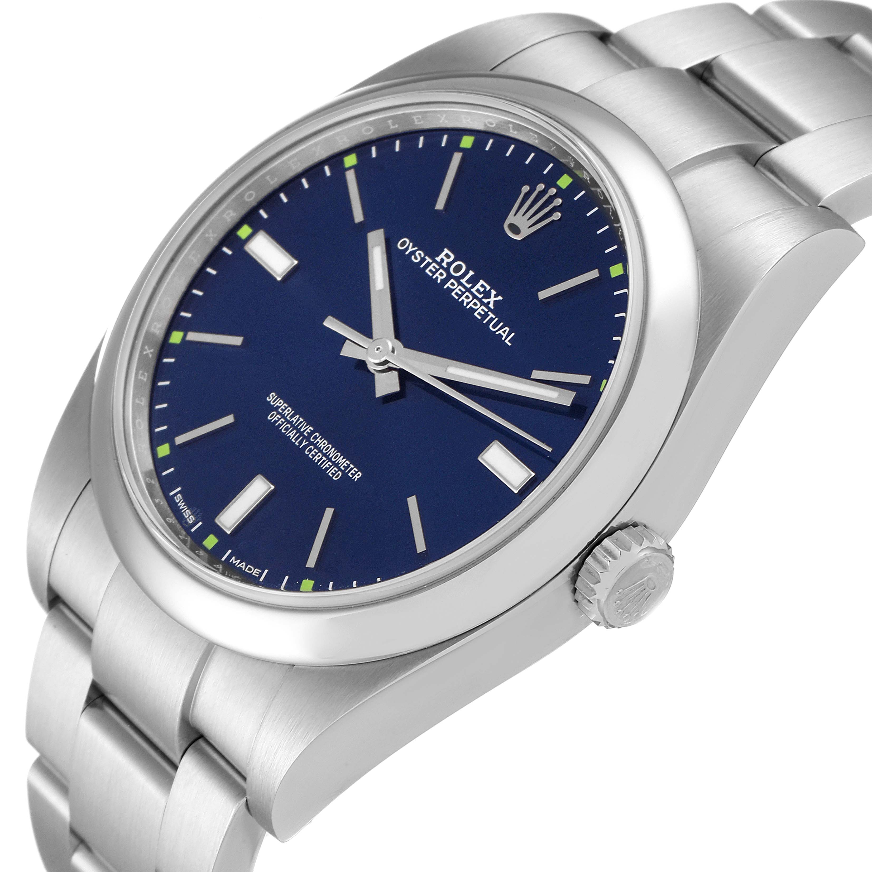 The image shows a Rolex Oyster Perpetual 114300 Men
s Stainless Steel Blue Dial 114300 Men
s Stainless Steel Blue Dial watch at an angled close-up, highlighting its blue dial, crown, and part of the bracelet.