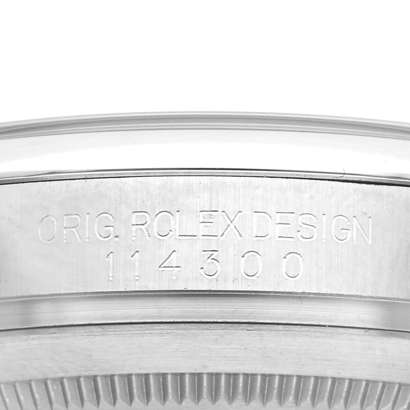 The image shows a close-up of the engraved side of the Rolex Oyster Perpetual 114300 Men's Stainless Steel Blue Dial 114300 Men's Stainless Steel Blue Dial watch case, displaying the model number 114300.