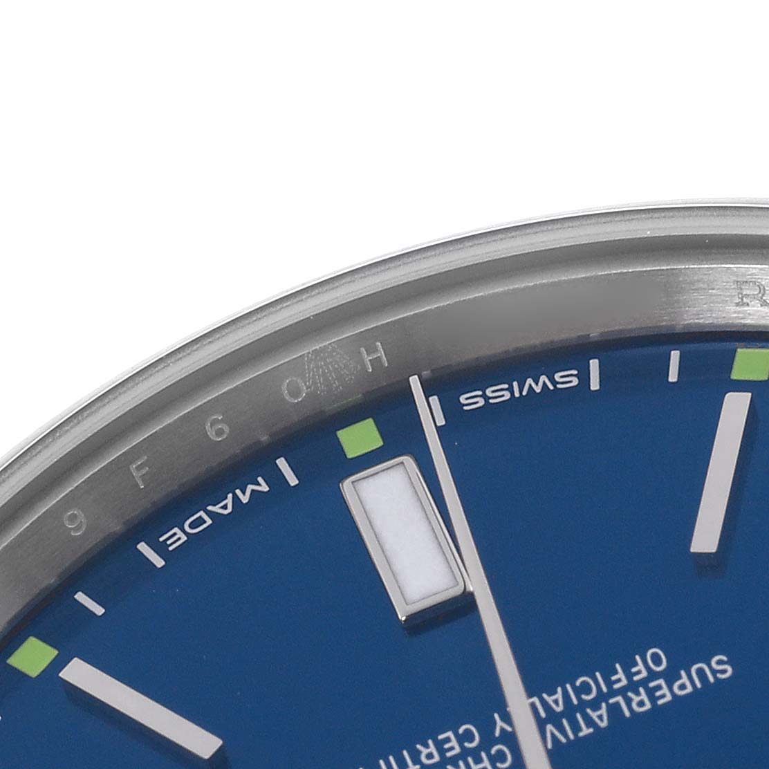 The image shows a close-up of the dial and bezel edge of a Rolex Oyster Perpetual 114300 Men's Stainless Steel Blue Dial 114300 Men's Stainless Steel Blue Dial watch, displaying part of the hour markers and text.