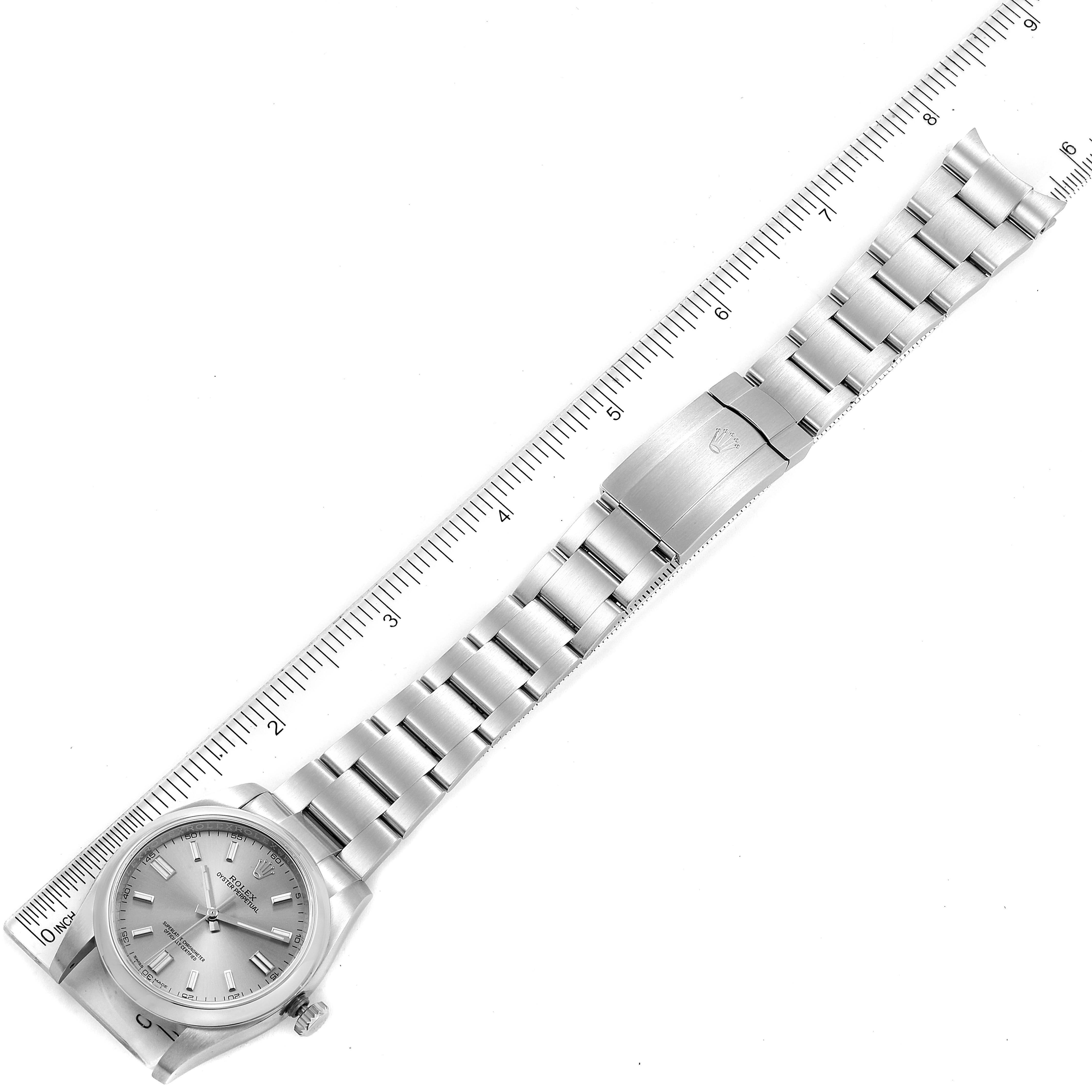 The image shows a top-down view of a Rolex Oyster Perpetual 116000 Men's Stainless Steel Grey Dial 116000 Men's Stainless Steel Grey Dial watch with its bracelet stretched out alongside a ruler.