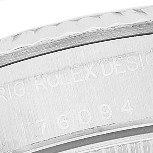 The image shows a close-up of the engraved serial number and "Rolex Design" inscription on the bezel of the Rolex Oyster Perpetual 76094 Women's Stainless Steel White Dial 76094 Women's Stainless Steel White Dial watch.