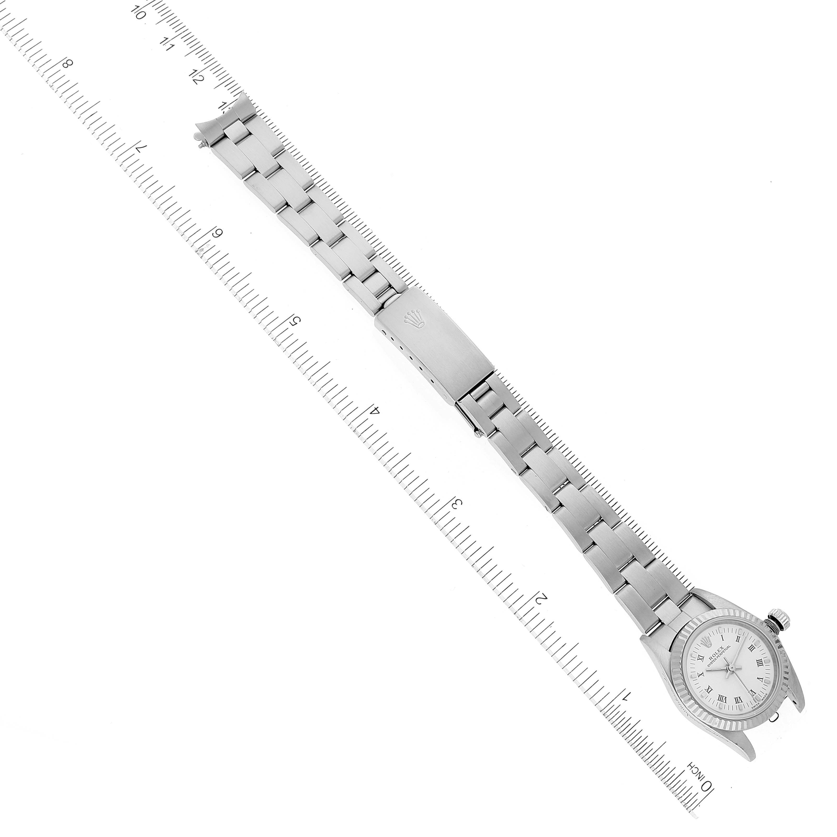 This is an overhead view of a Rolex Oyster Perpetual 76094 Women's Stainless Steel White Dial 76094 Women's Stainless Steel White Dial watch showing the full bracelet, clasp, lug, and dial.