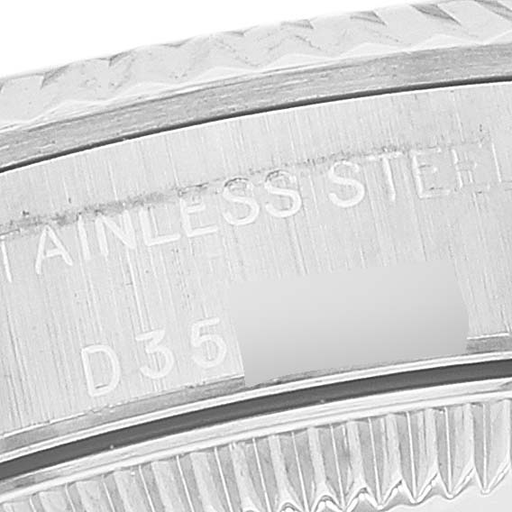 This close-up image shows the engraved text on the case back of a Rolex Oyster Perpetual 76094 Women's Stainless Steel White Dial 76094 Women's Stainless Steel White Dial watch, highlighting "STAINLESS STEEL" and part of a serial number.