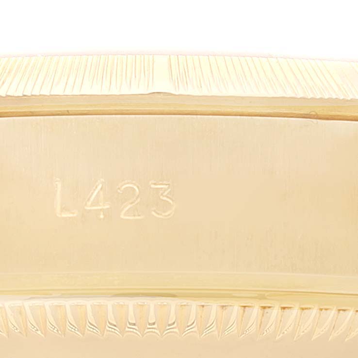 The image shows the side of the case of a Rolex President 69278 Women
s Yellow Gold White Dial 69278 Women
s Yellow Gold White Dial model watch with the serial number engraved.