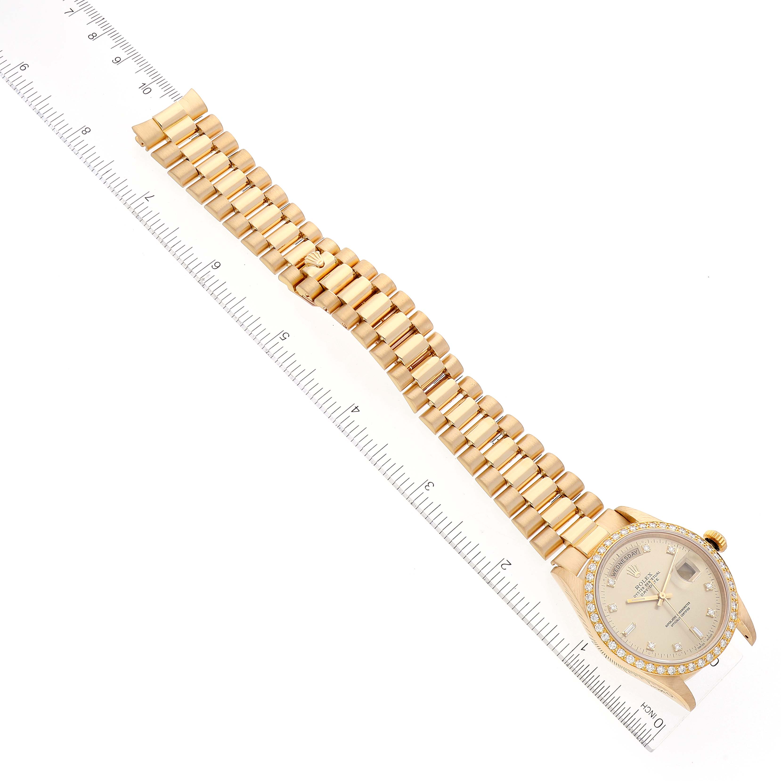 The image shows a top-down view of a Rolex President 18348 Men's Yellow Gold Champagne Dial 18348 Men's Yellow Gold Champagne Dial model watch with its gold bracelet and face aligned against a ruler.